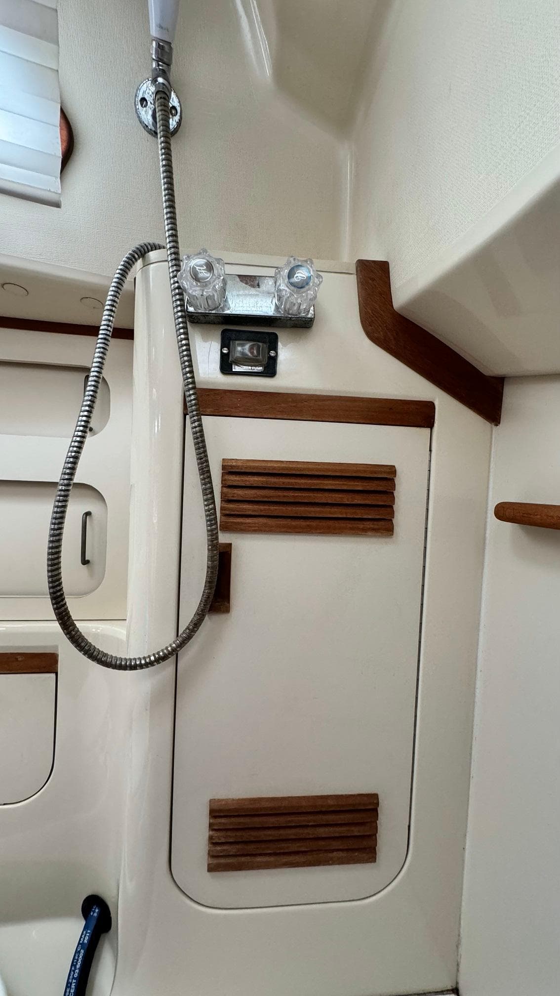 Interior of 1990 Sabre 38 sailboat with shower and wooden accents.