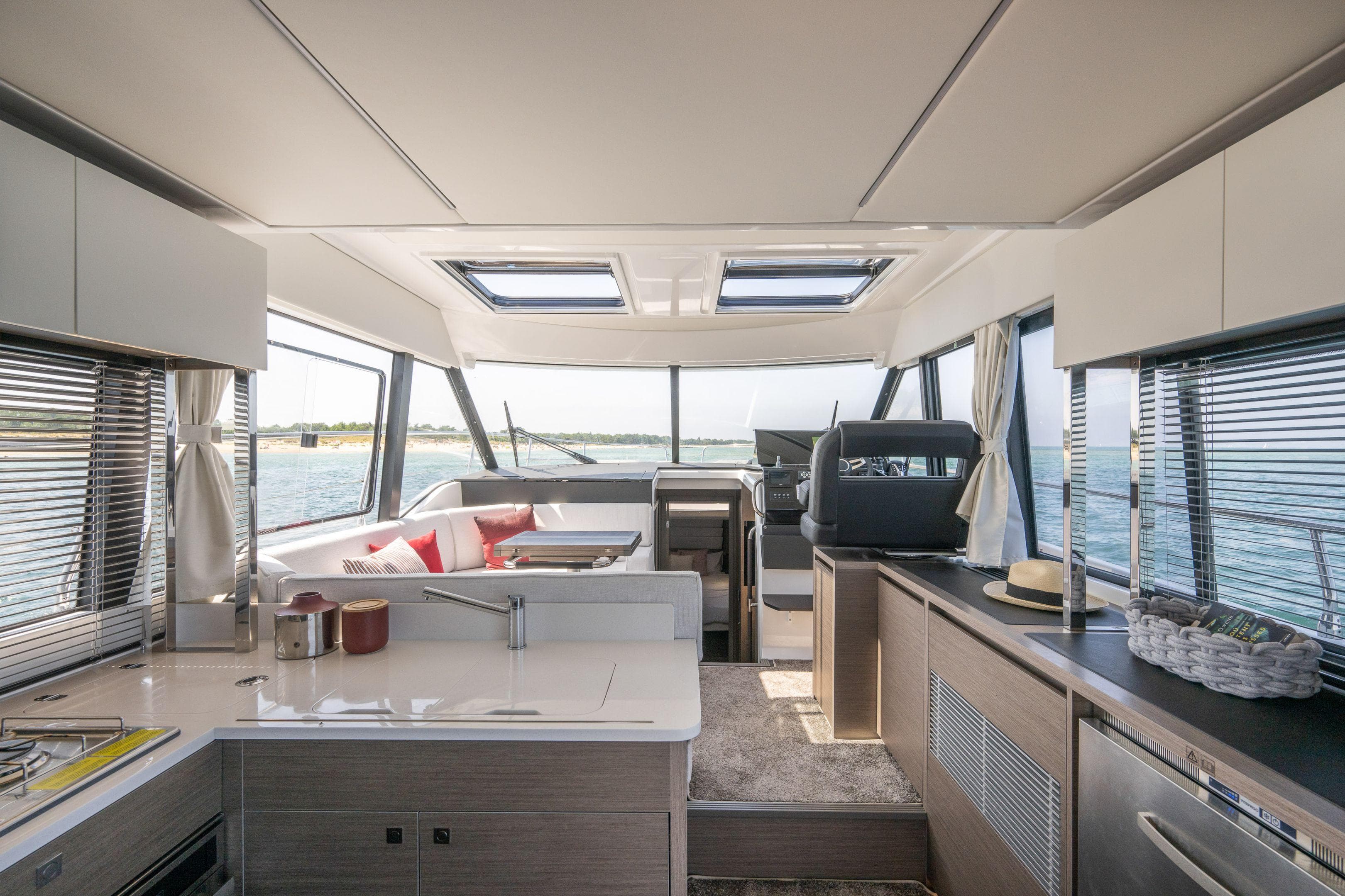 Interior of 2025 Jeanneau NC 1295 Coupe yacht, featuring modern design and panoramic windows.