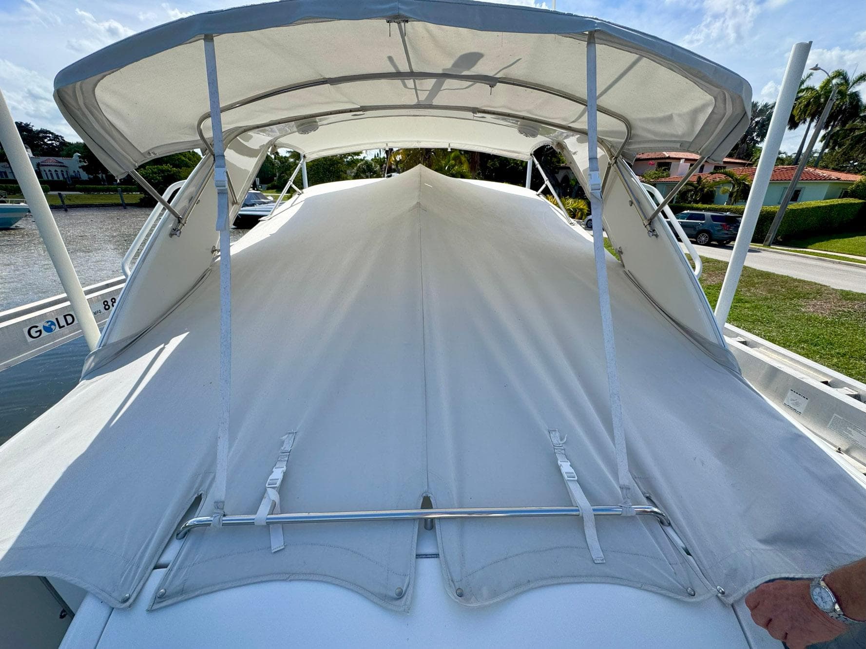 1999 Formula 400 Super Sport boat with white canopy and cover, docked near a canal.
