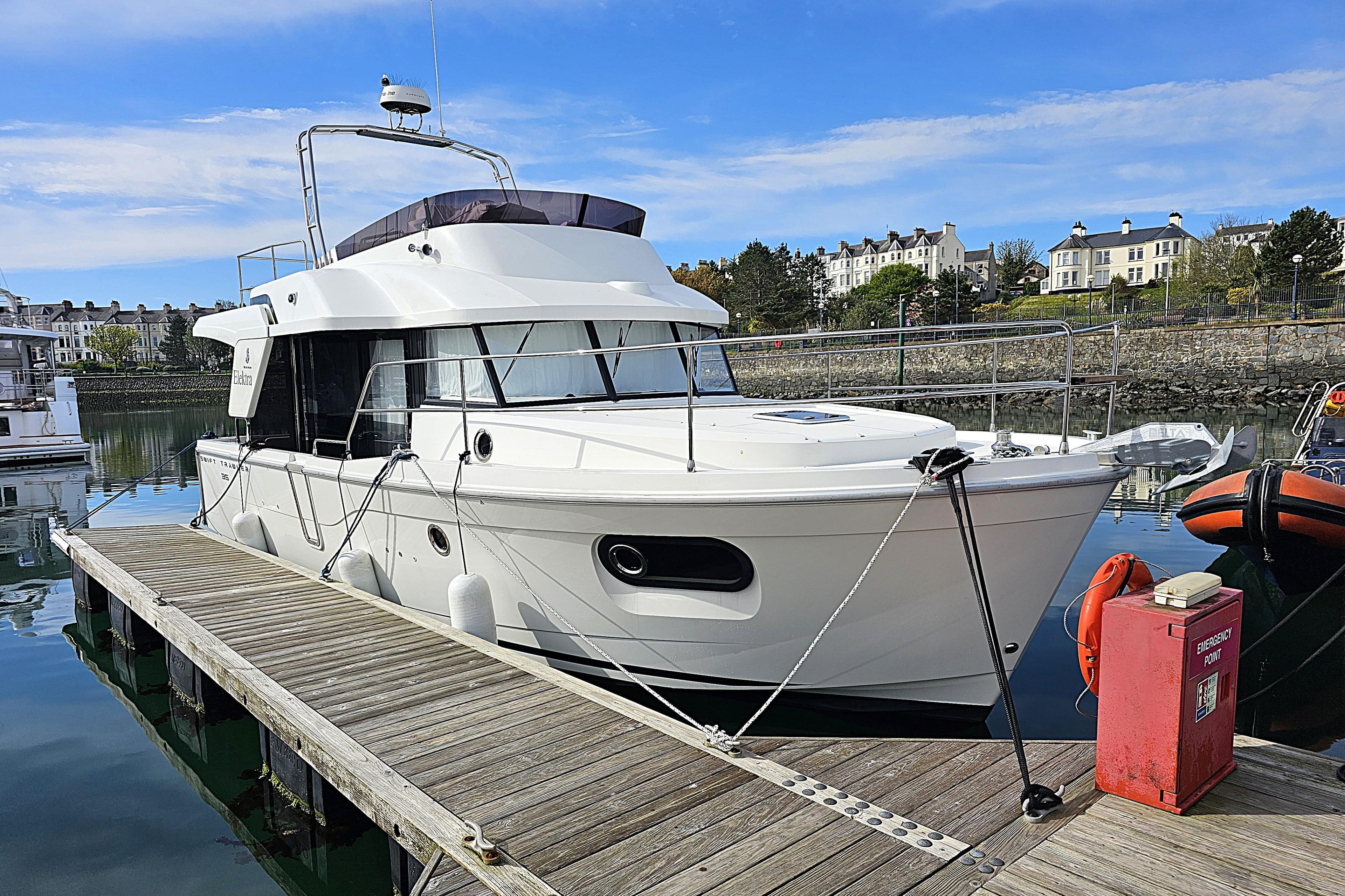 2018 Beneteau Swift Trawler 35 docked at a marina, under a clear blue sky.