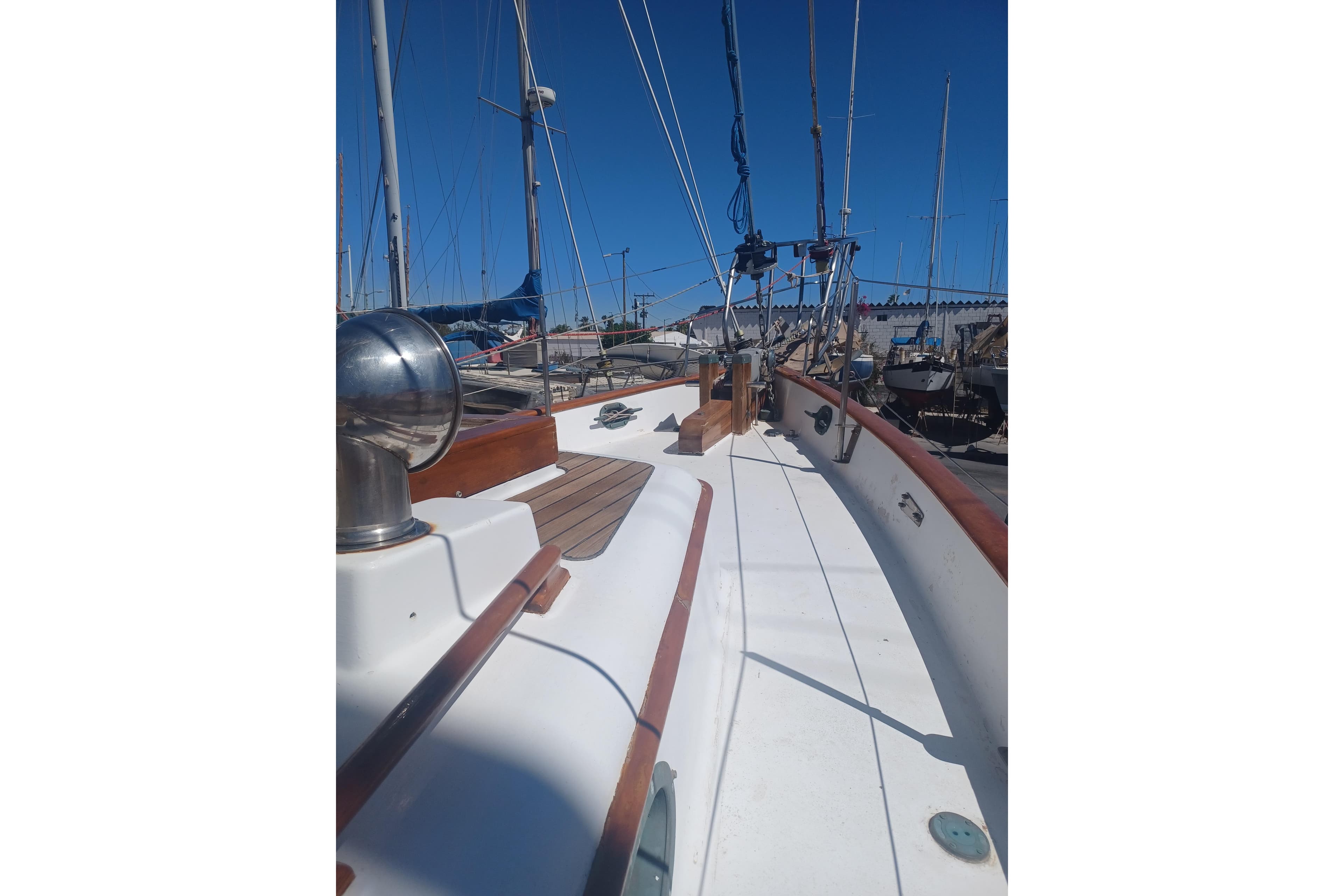 1980 Hans Christian 43 sailboat deck with wooden accents and clear blue sky.