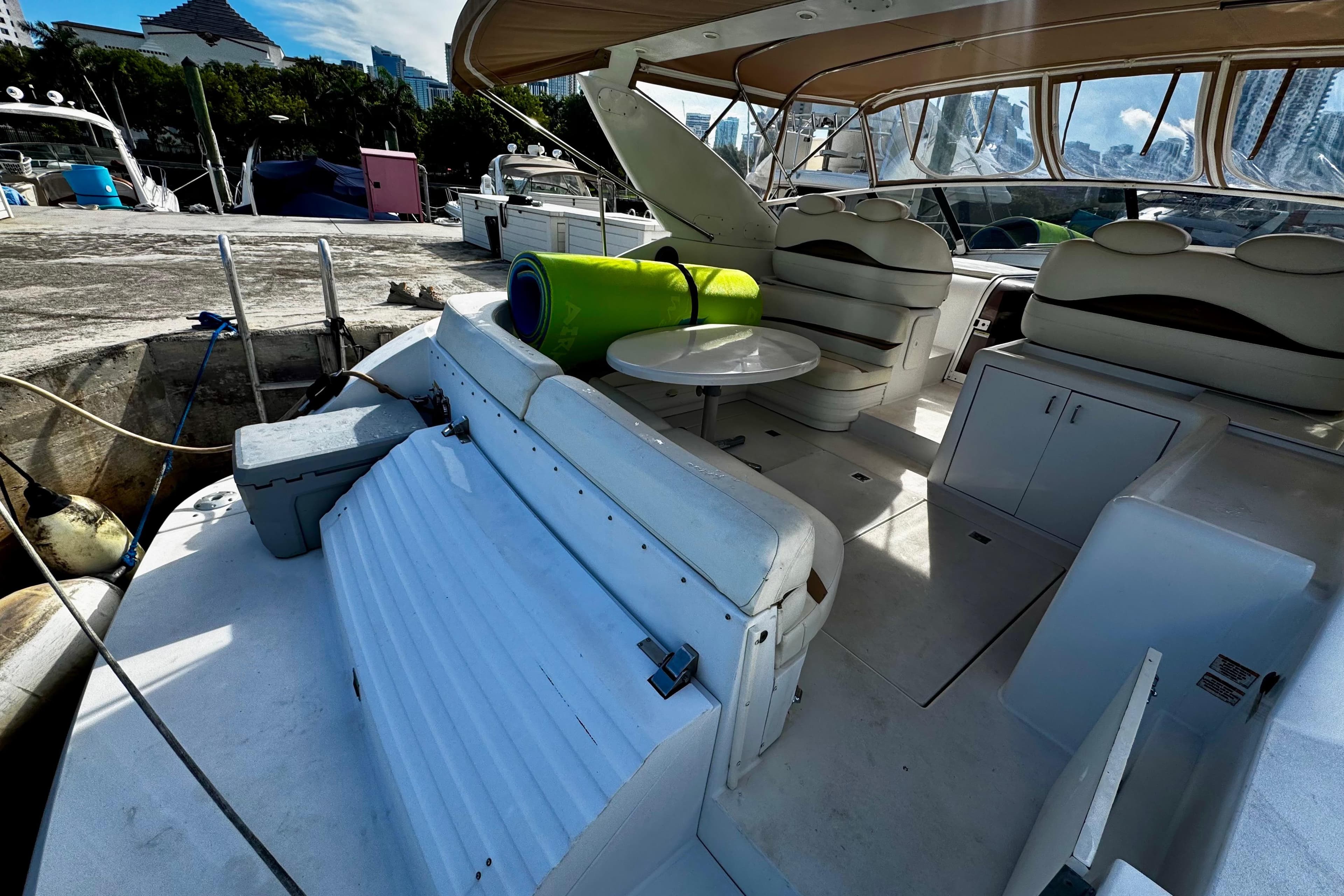 Trojan 440 Express 2000 yacht interior with seating and table at marina.