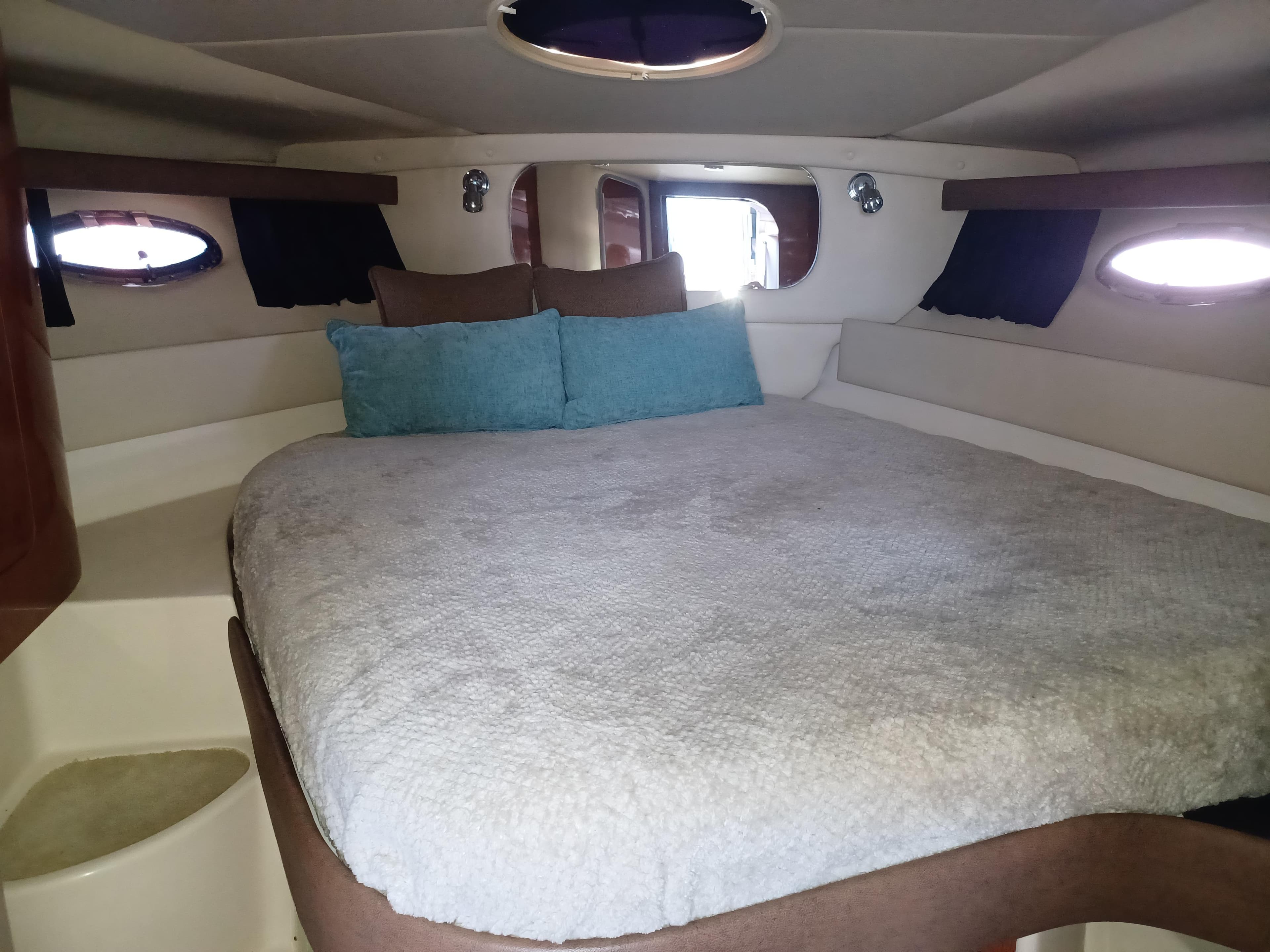 2008 Regal 4060 COMMODORE cabin interior with cozy bed and porthole windows.