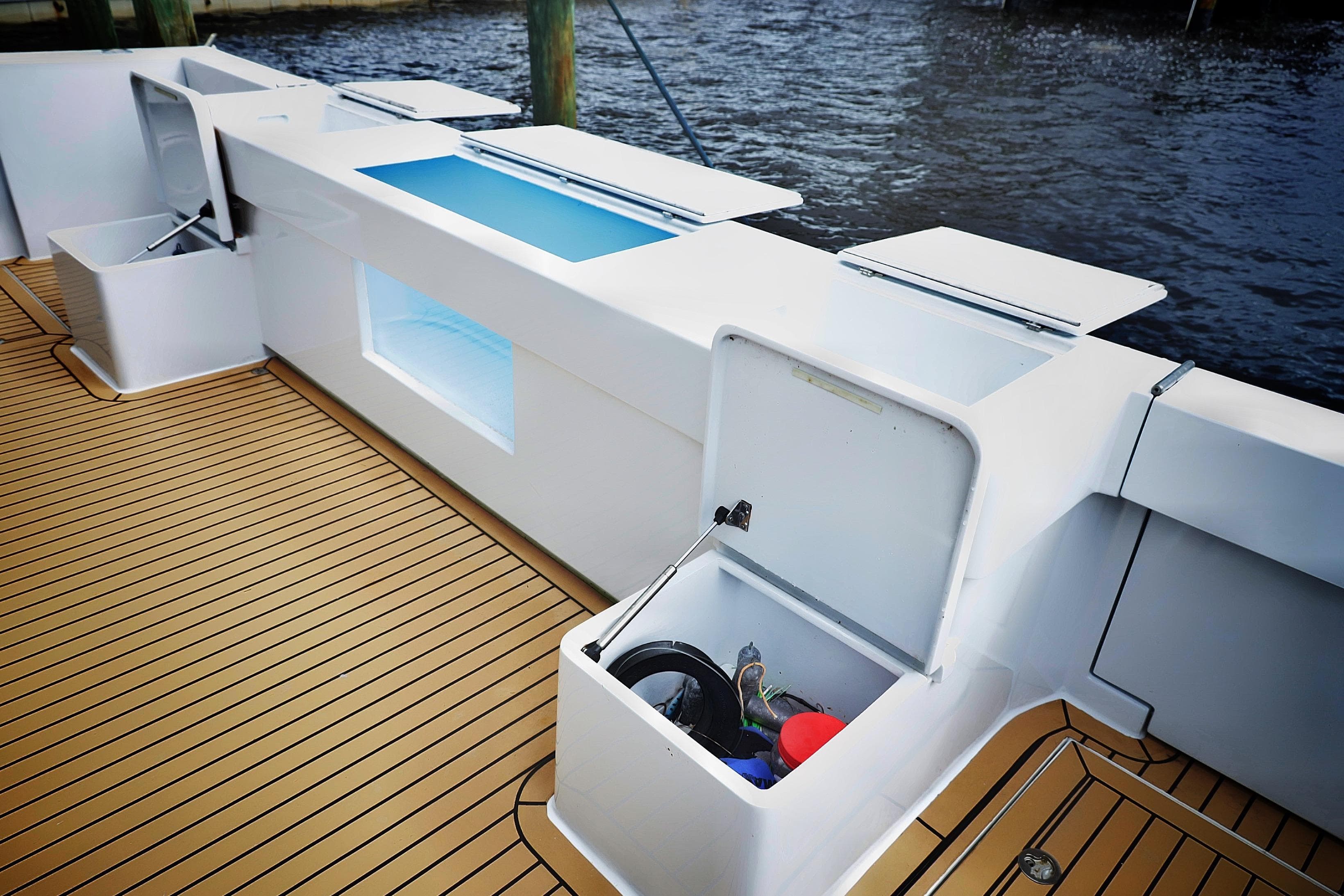 Deck of 2000 Venturer 44 boat with open storage compartments and teak flooring.