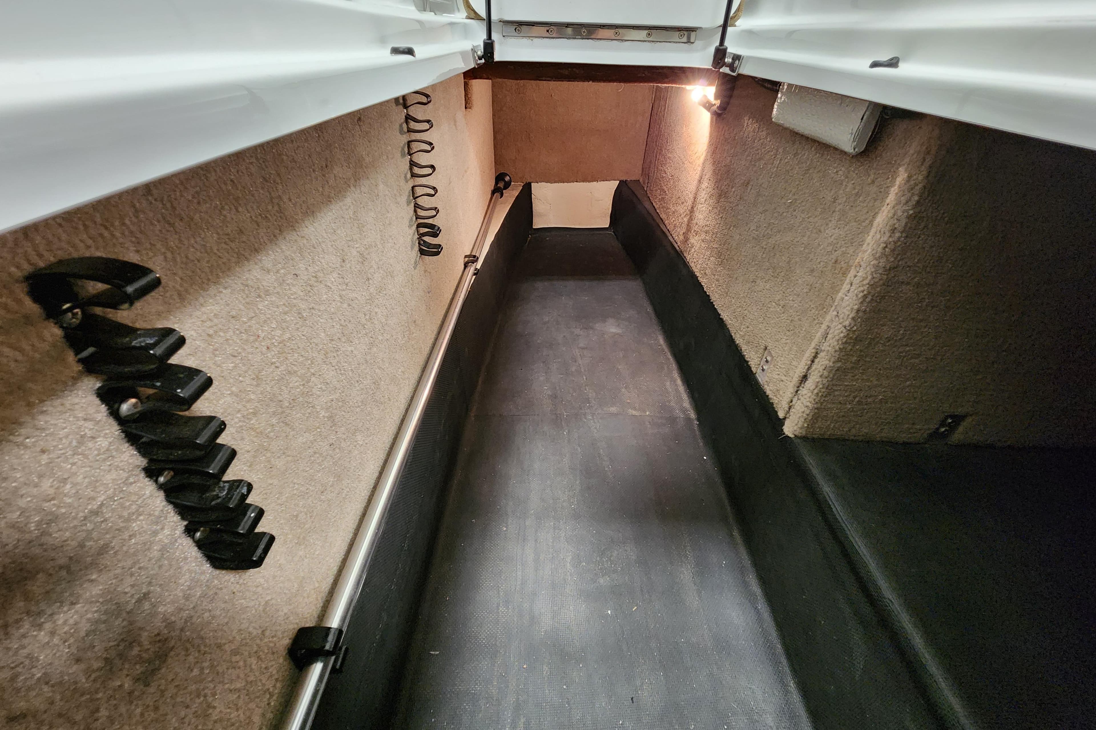 Interior storage compartment of a 2012 Cobalt 296 boat, featuring carpeted walls and lighting.