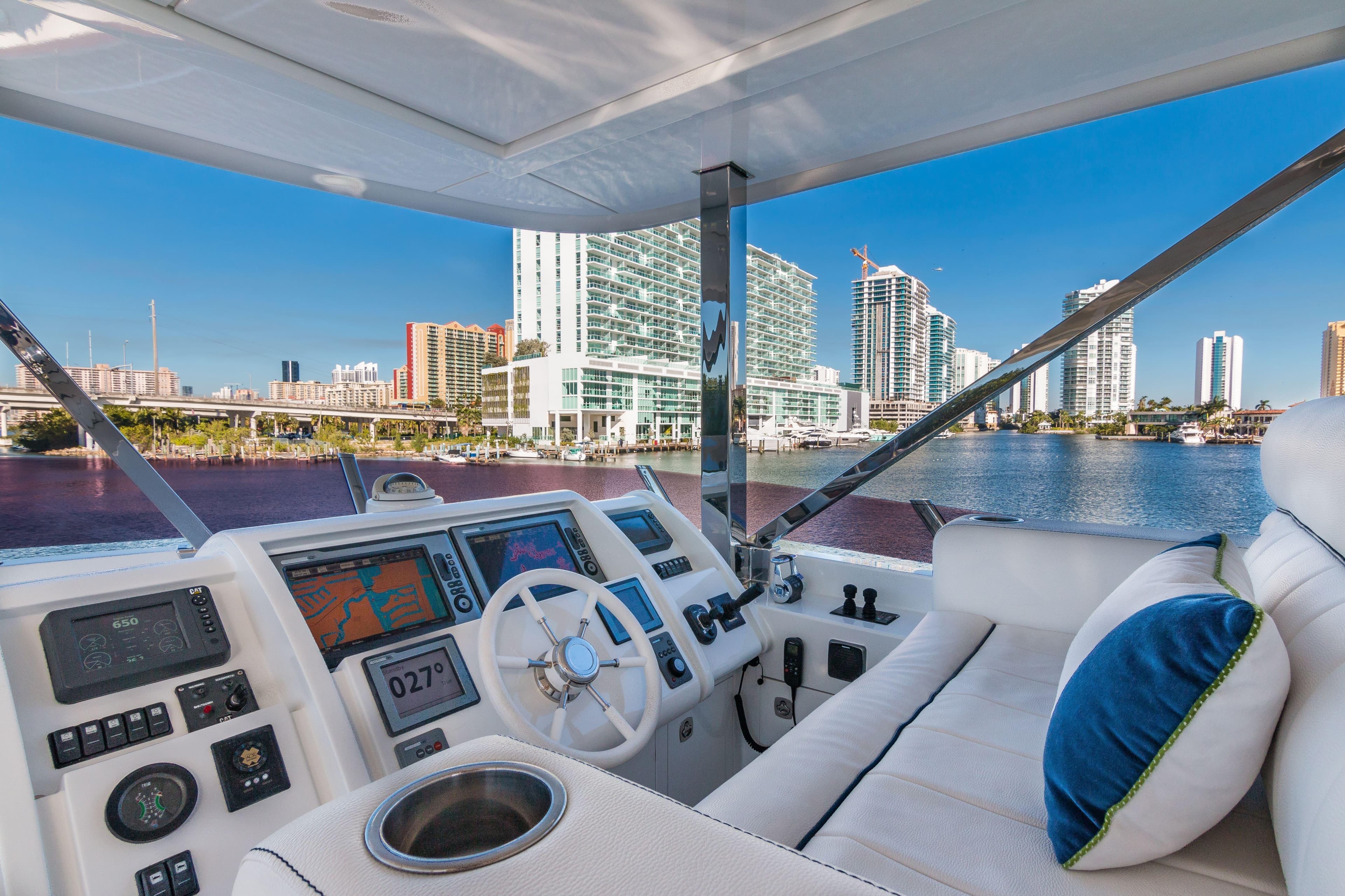 Luxurious 2013 Vicem Raised Pilothouse Motoryacht helm with city skyline view.