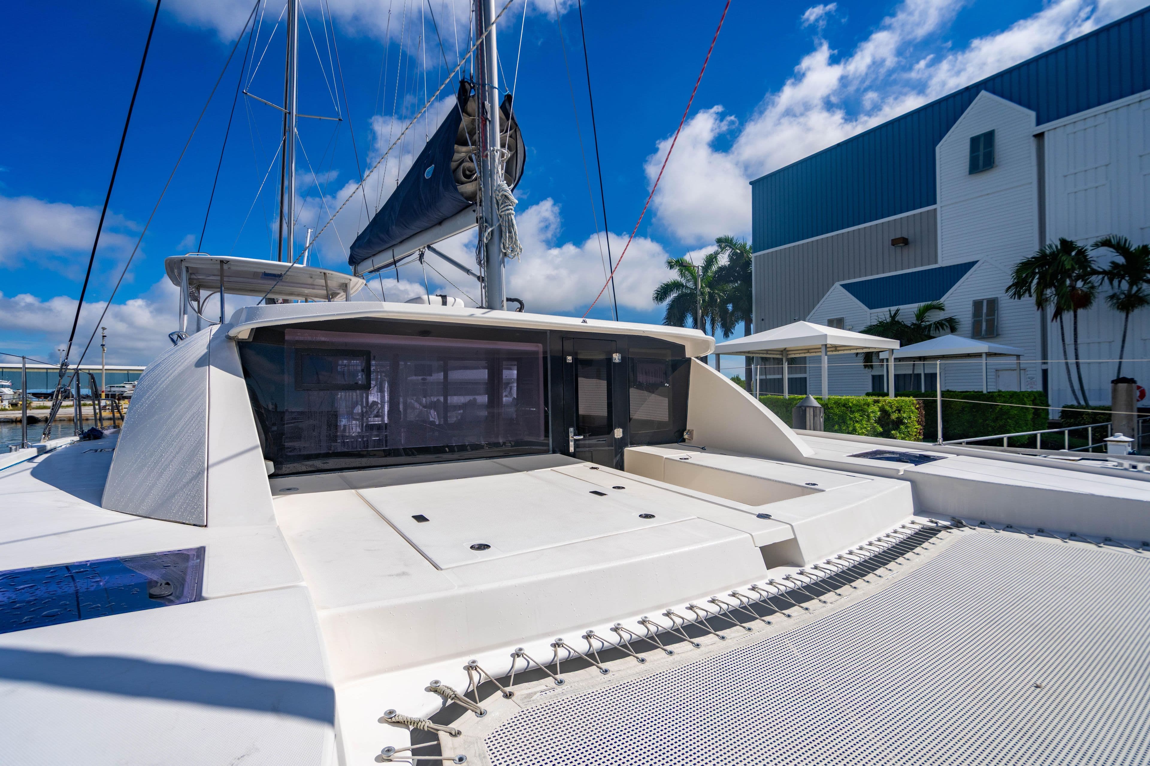 2016 Leopard 40 catamaran docked, showcasing deck and sail against blue sky.