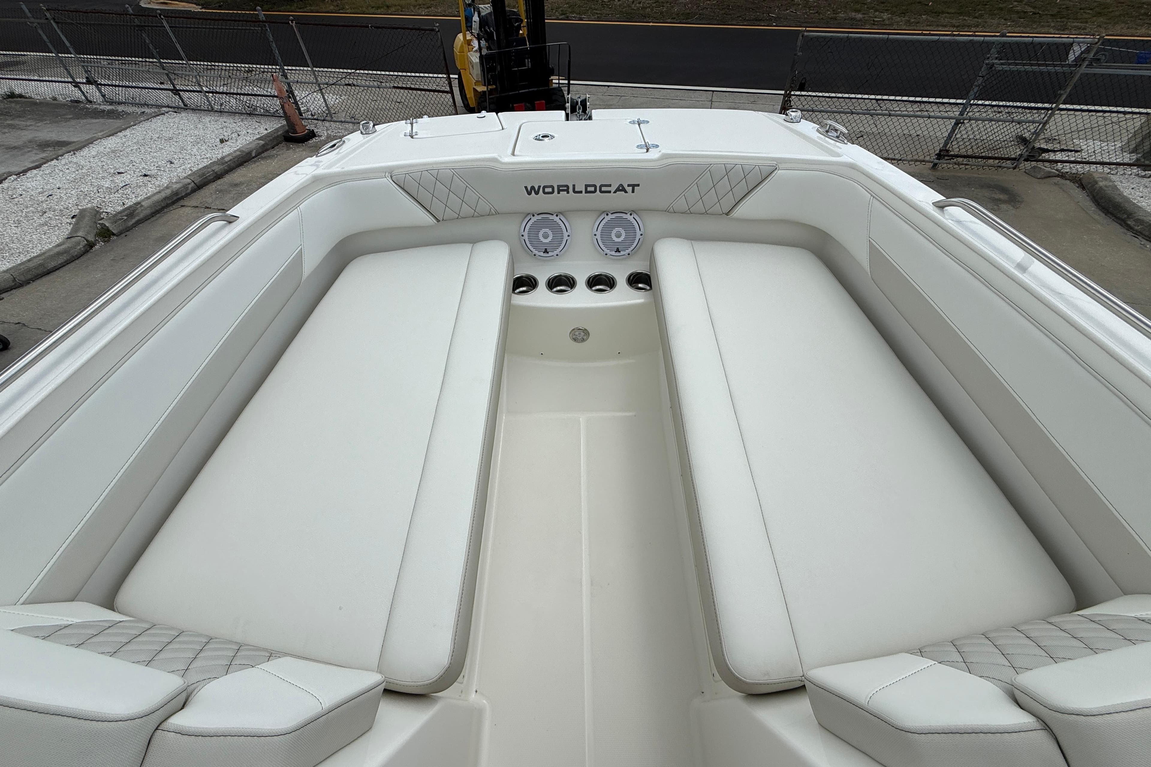 2026 World Cat 230 SD boat interior with white cushioned seating and speaker system.