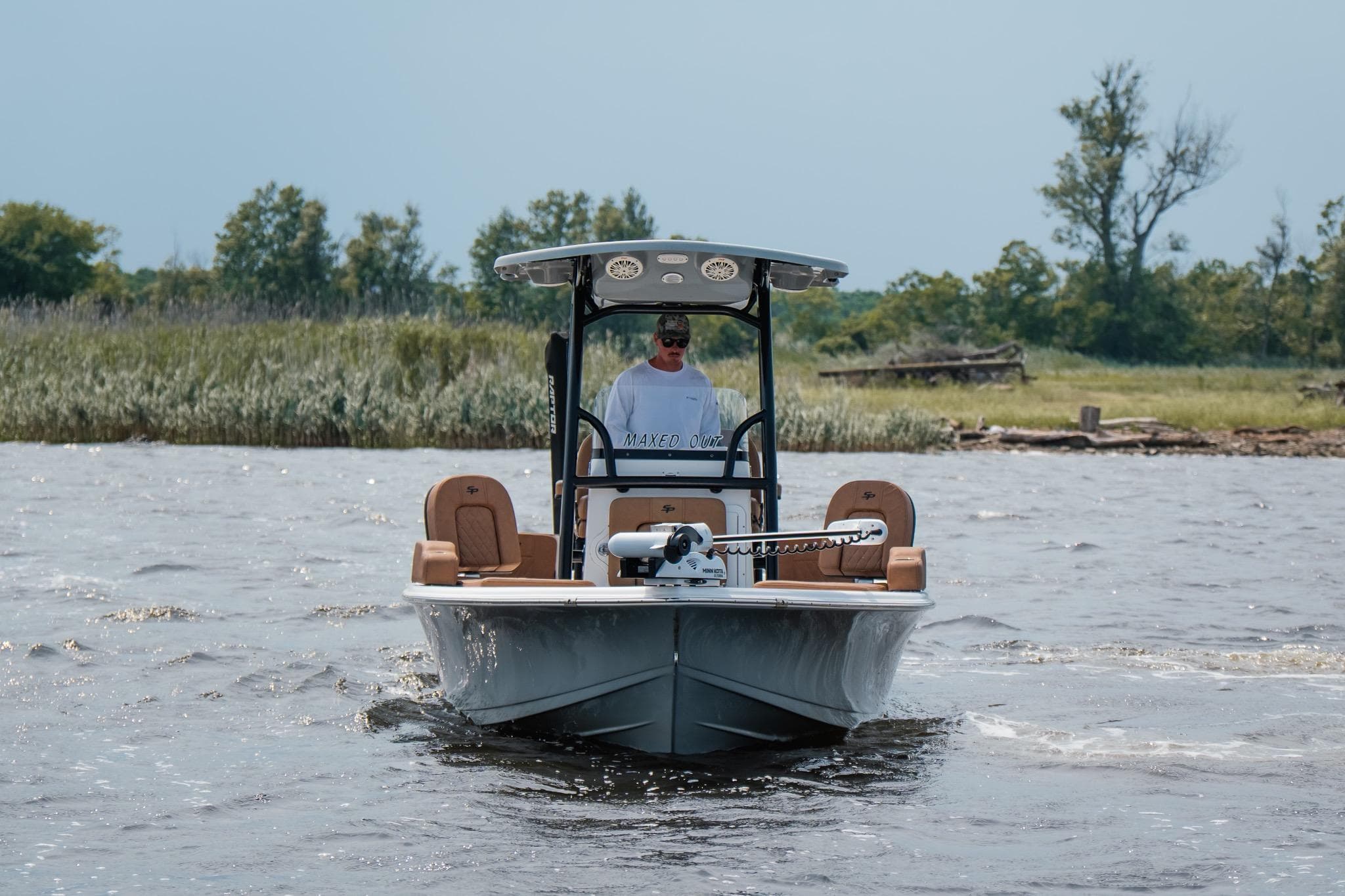 2022 Sea Pro 228 Bay boat cruising on a scenic waterway with lush greenery.