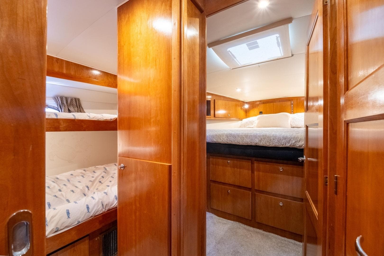 Luxurious wooden interior of 2003 Navigator 5700 yacht with cozy bunk beds and skylight.