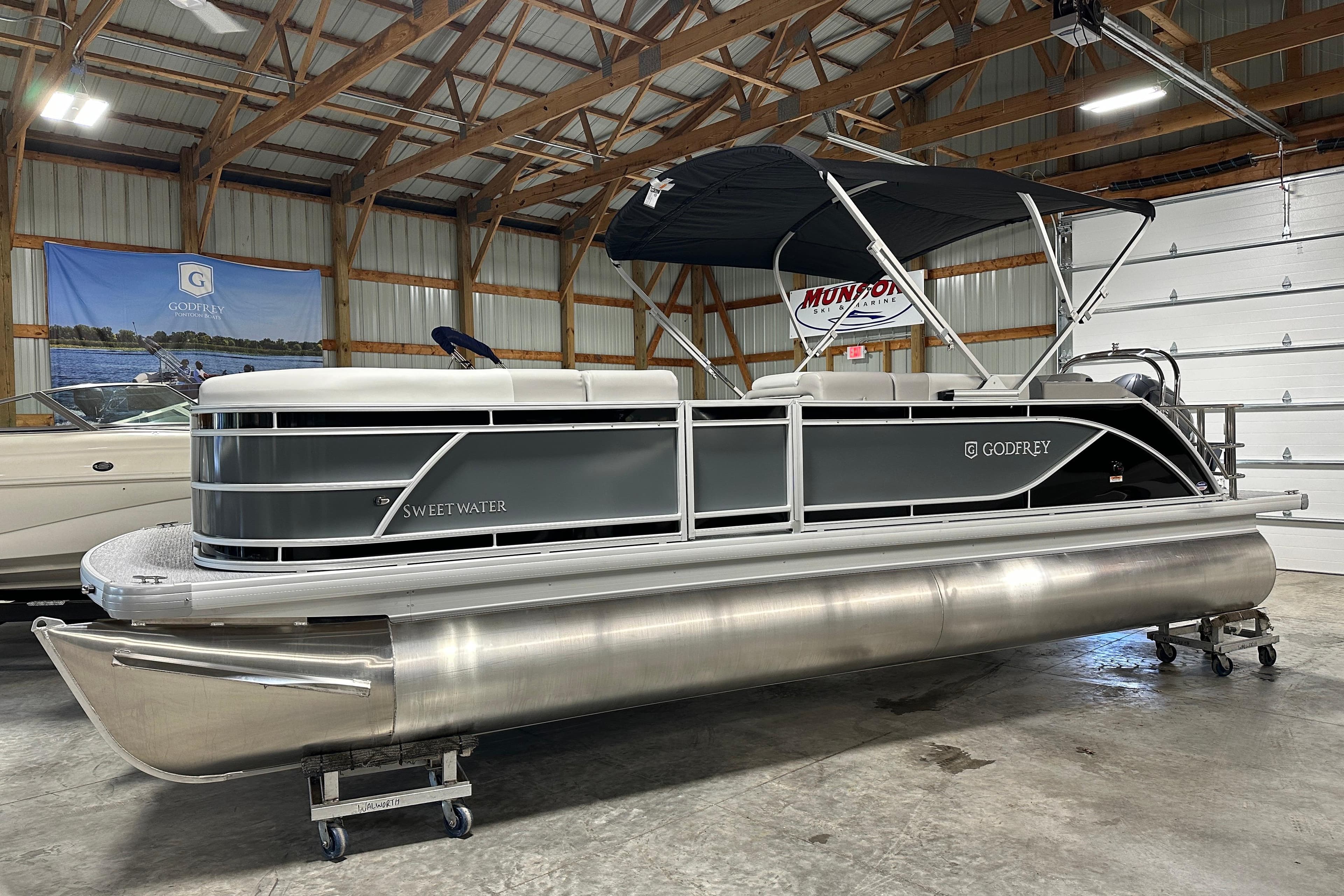 2026 Godfrey SWEETWATER 2286 SFL pontoon boat in a showroom setting.