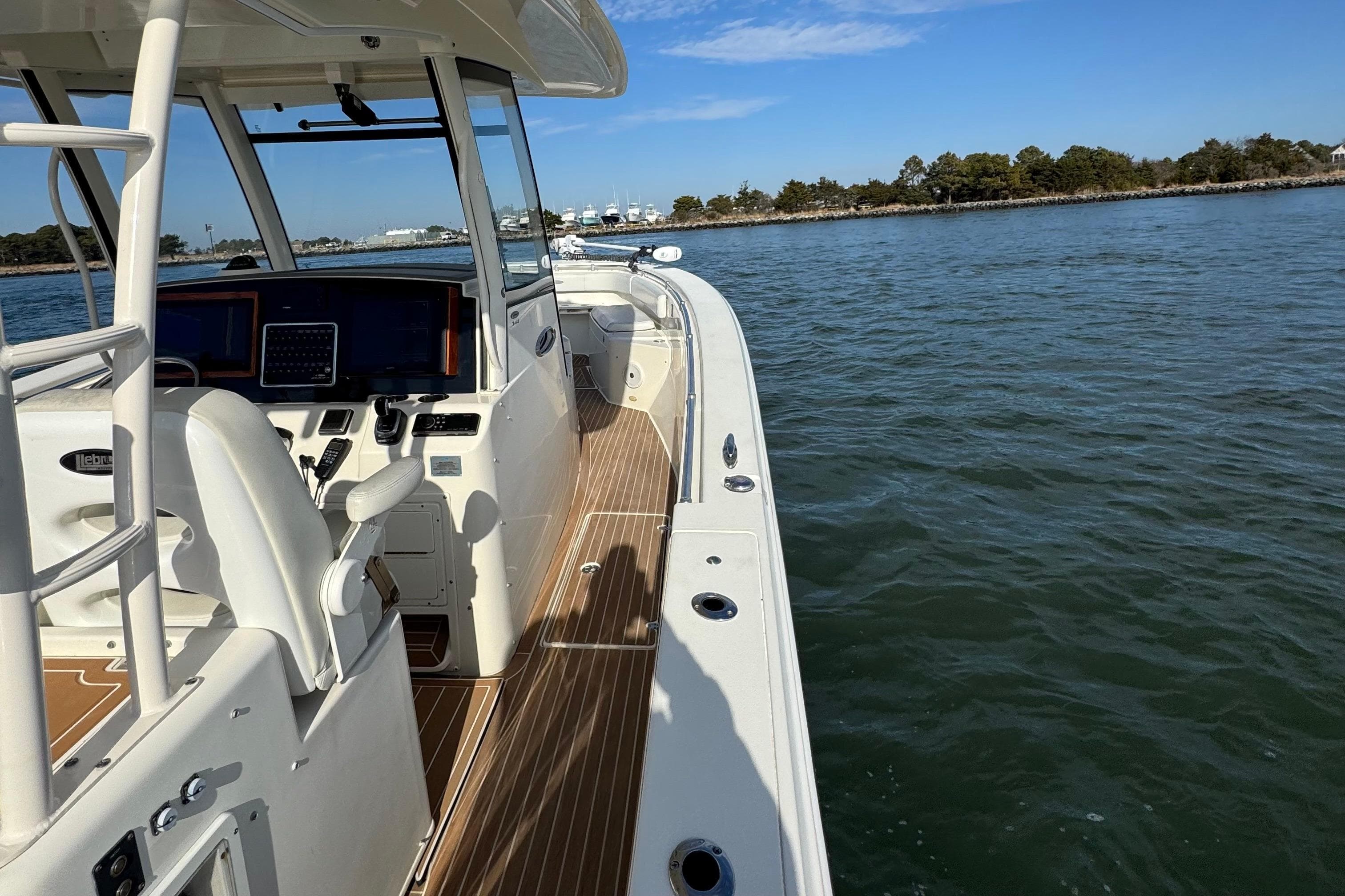 2015 Cobia 344 Center Console boat on calm water, featuring a sleek deck design.