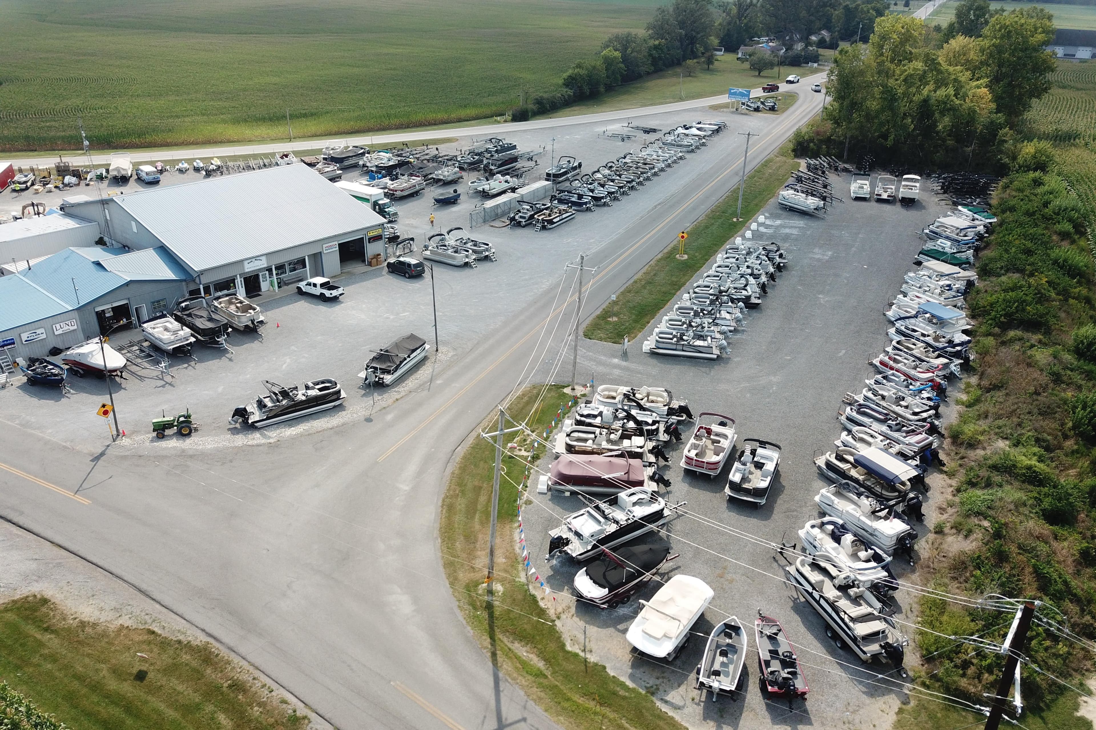 Aerial view of a boat dealership showcasing various boats, including the 2026 Sylvan Mirage 8520 CLZ DH.
