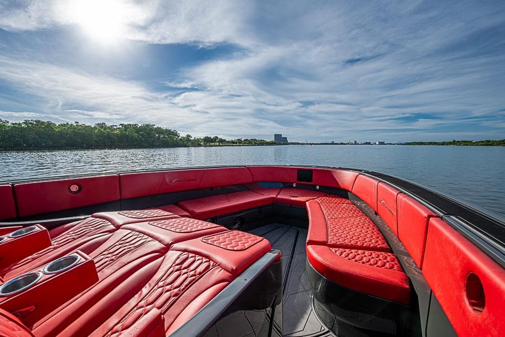 Luxurious 2021 Midnight Express 43 Solstice boat with red seating on a serene lake.