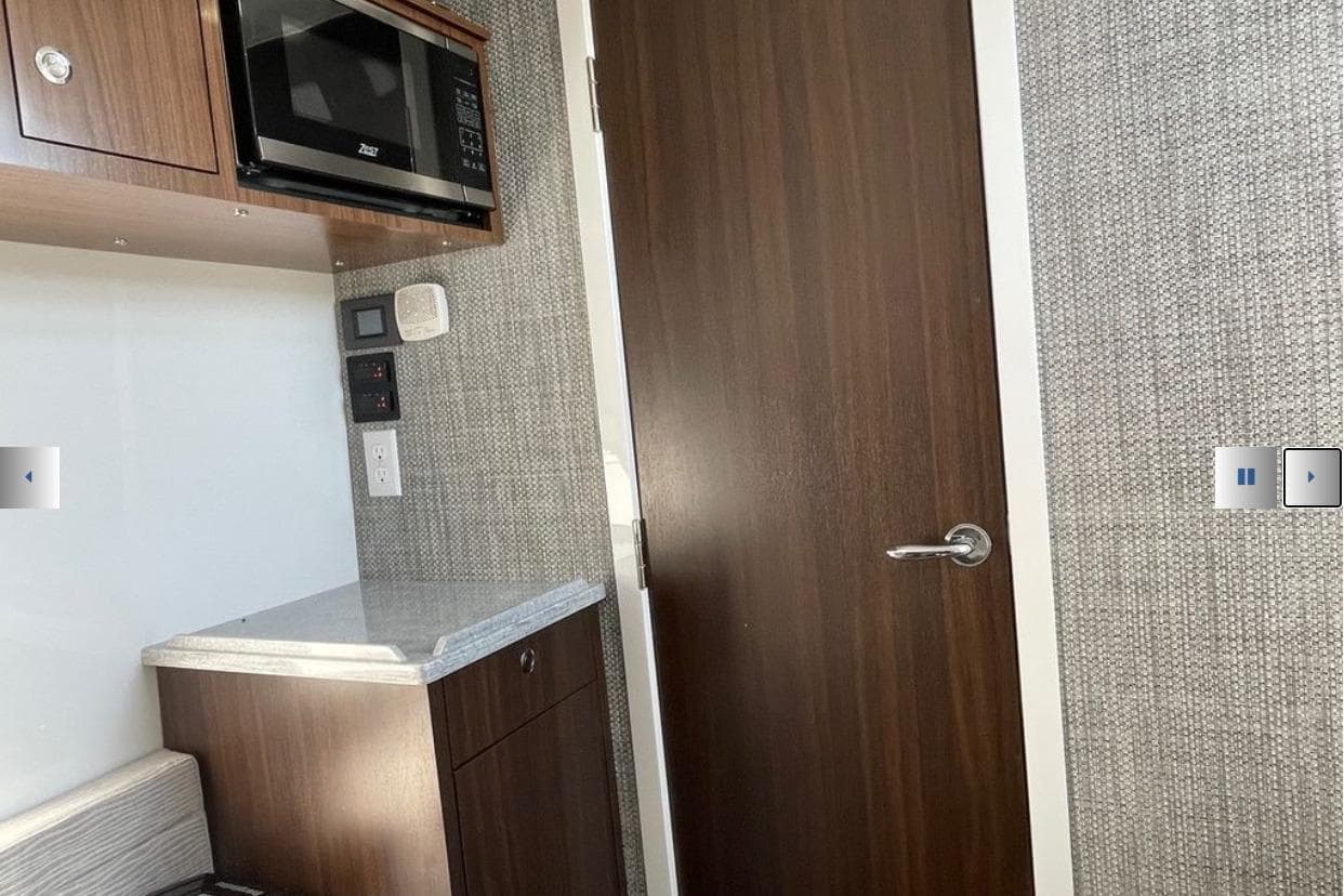 Interior of 2025 Everglades 395 Center Console with microwave and wooden cabinetry.
