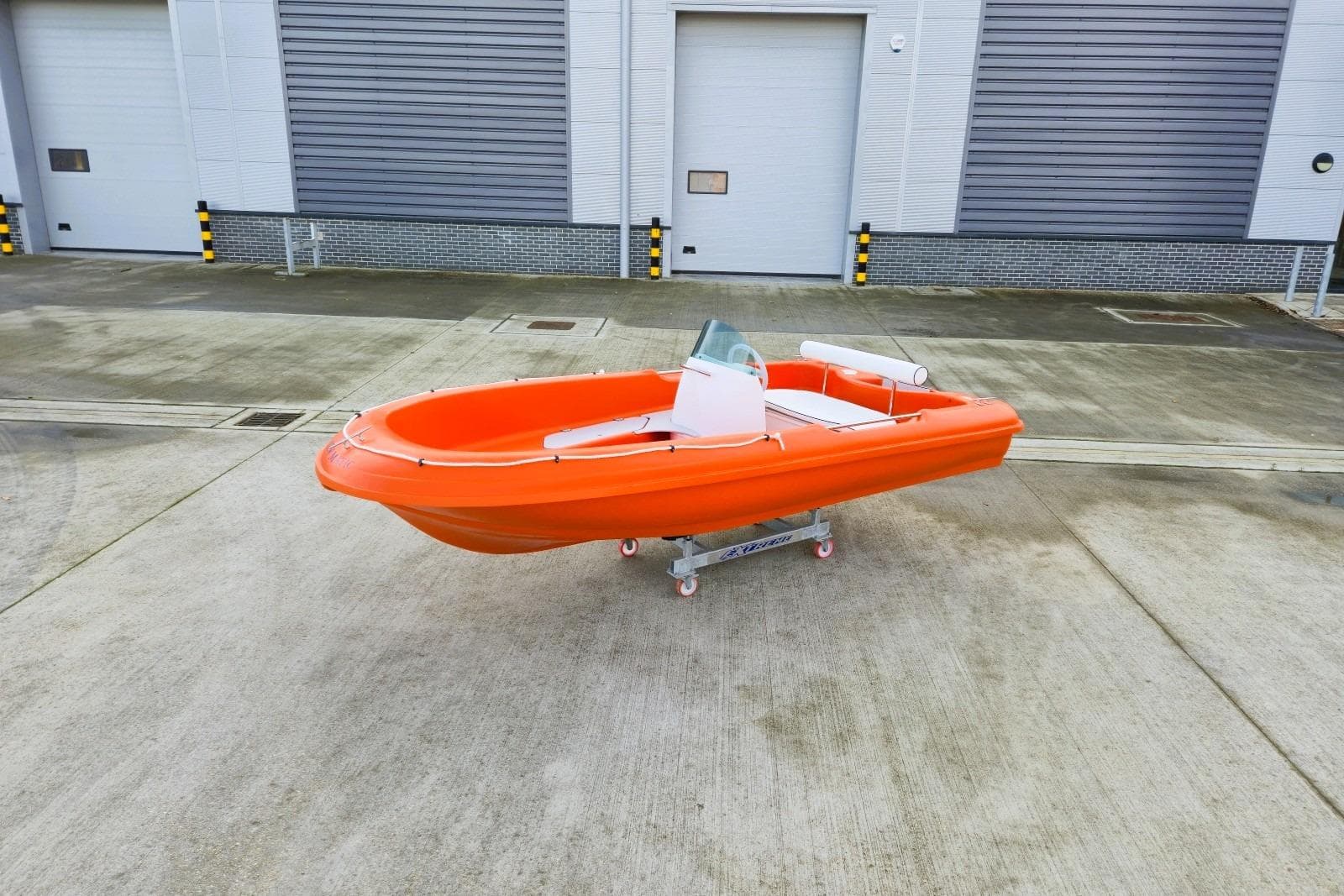 Orange Rigiflex New Matic 400 Console boat, 2025 model, on concrete surface.