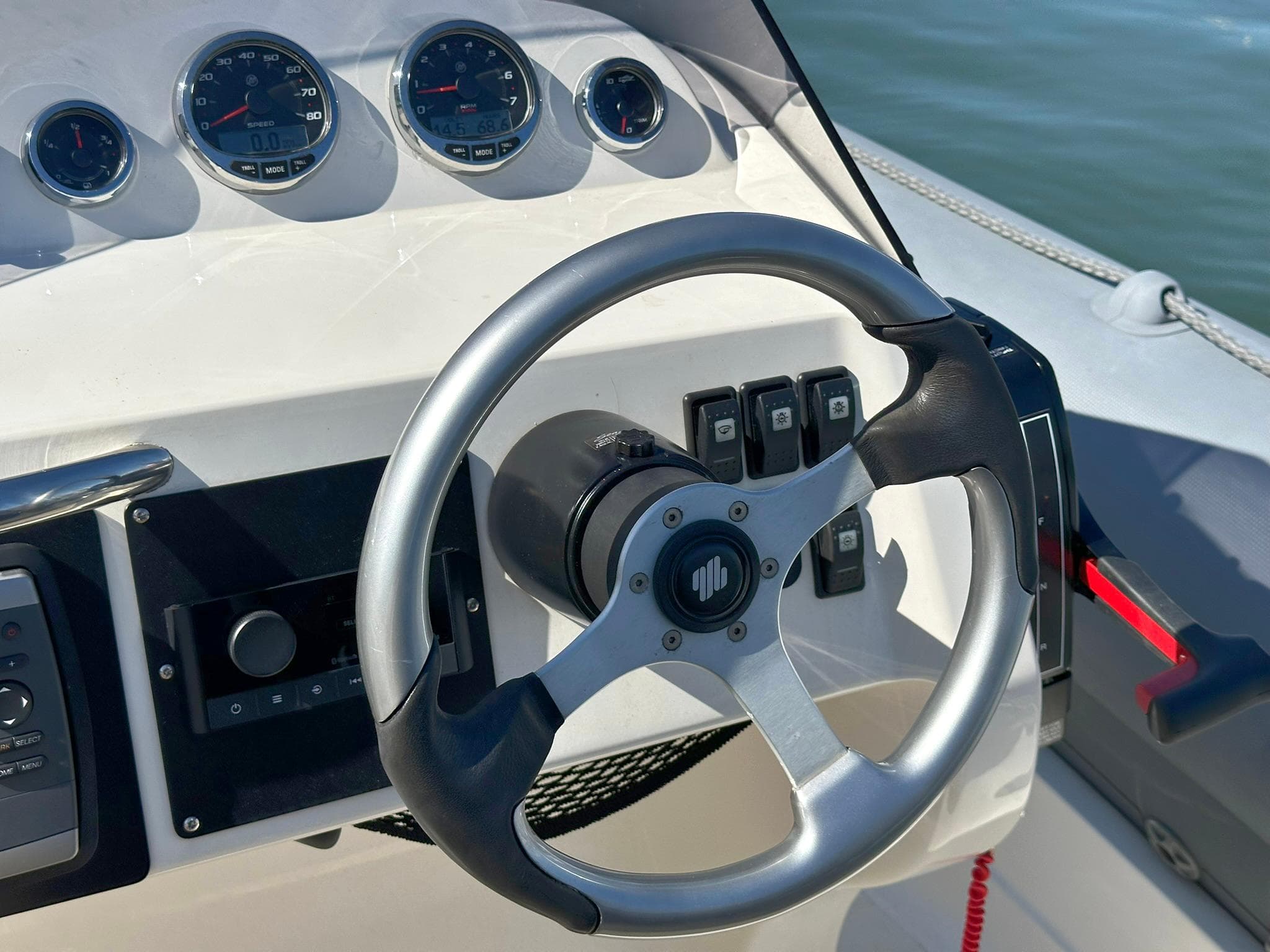 Steering wheel and dashboard of 2004 Revenger 715 boat with gauges and controls.