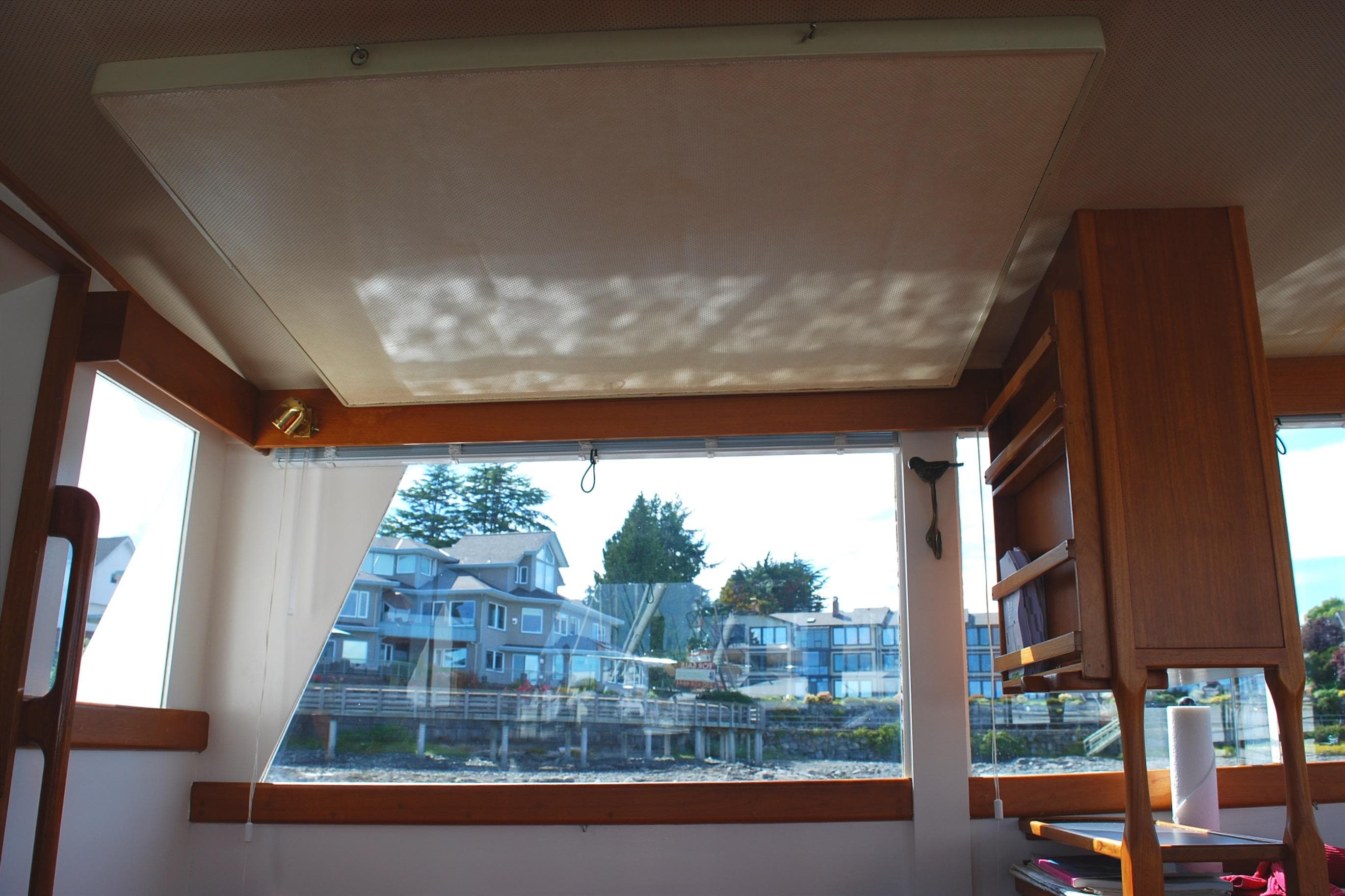 Interior view of 1971 Grand Banks 36 Classic yacht with large window and wooden cabinetry.