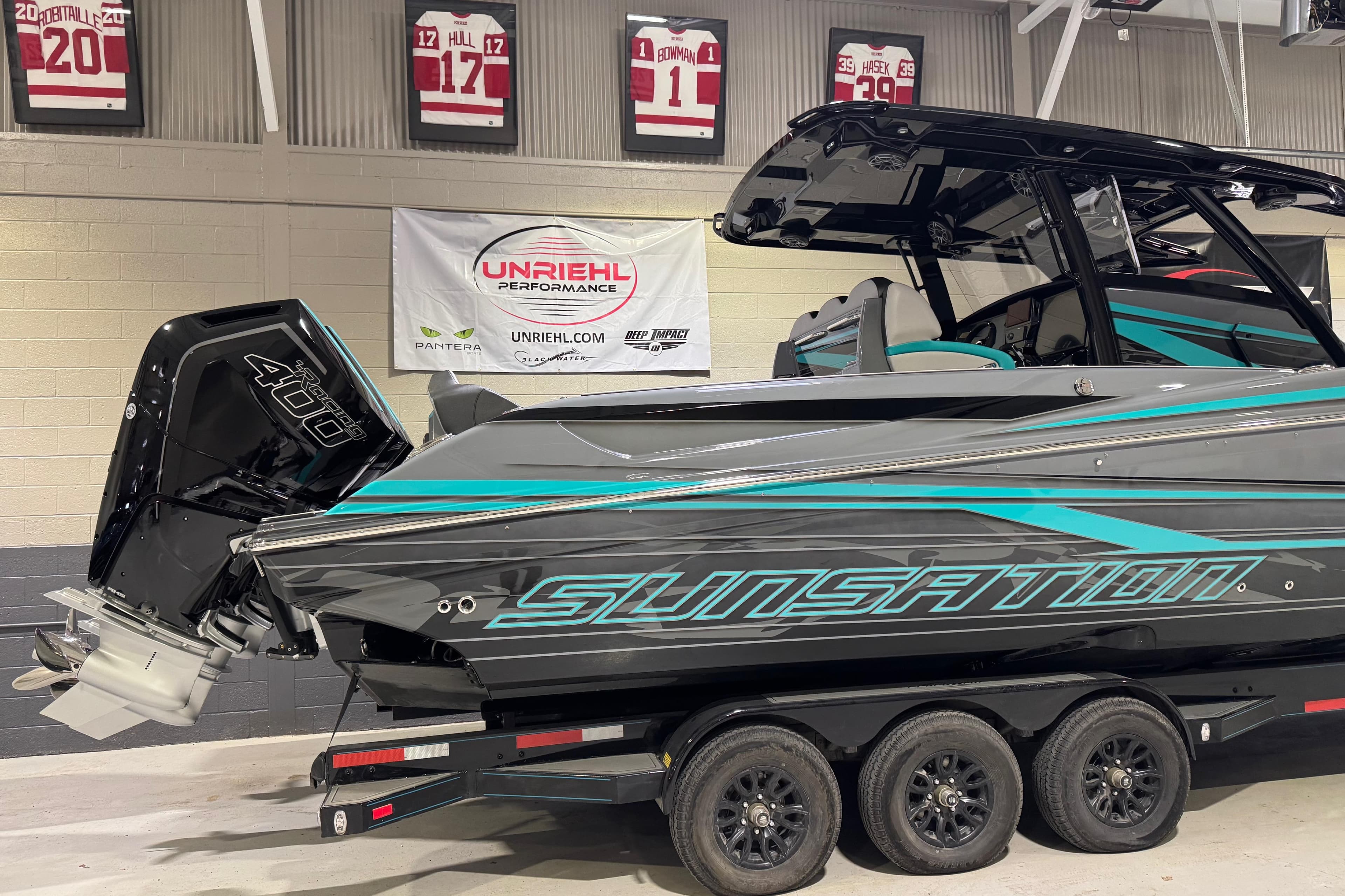 2026 Sunsation 34 CCX boat with powerful engine on display indoors.