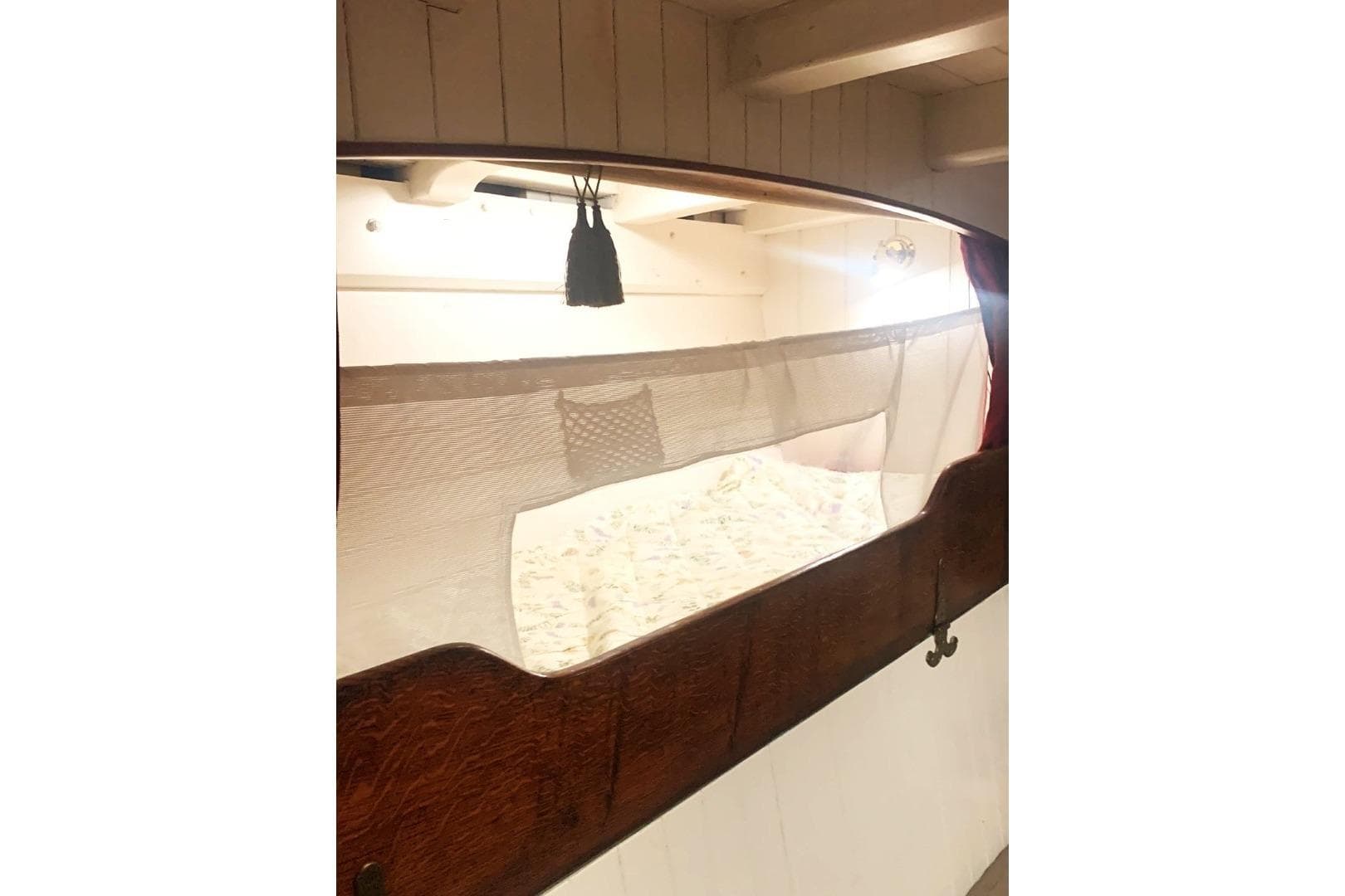 Cozy cabin interior of 1899 Classic Bristol Pilot Cutter with wooden accents.