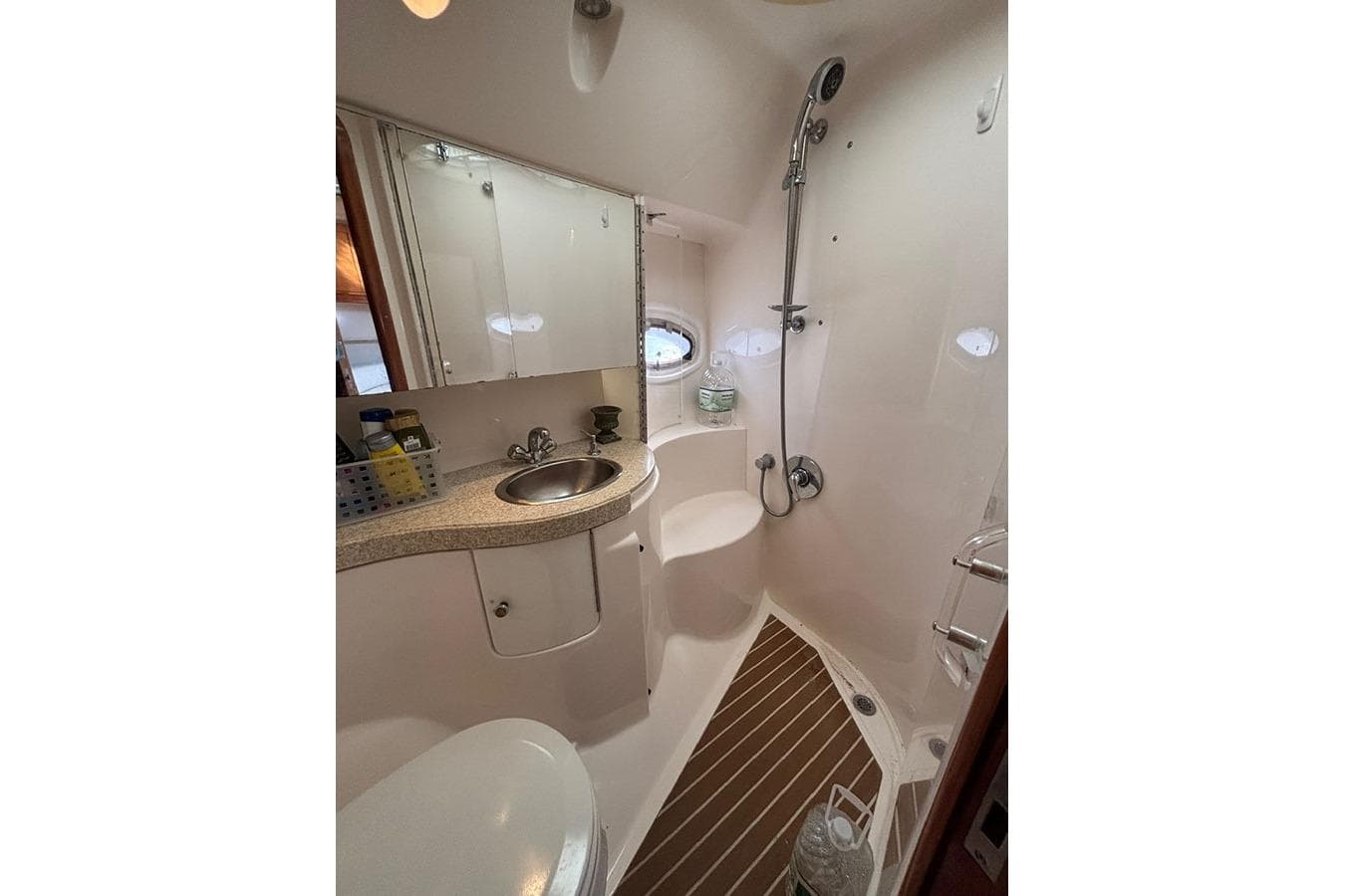 Compact bathroom in 2005 Regal Commodore 4260 yacht with shower and sink.