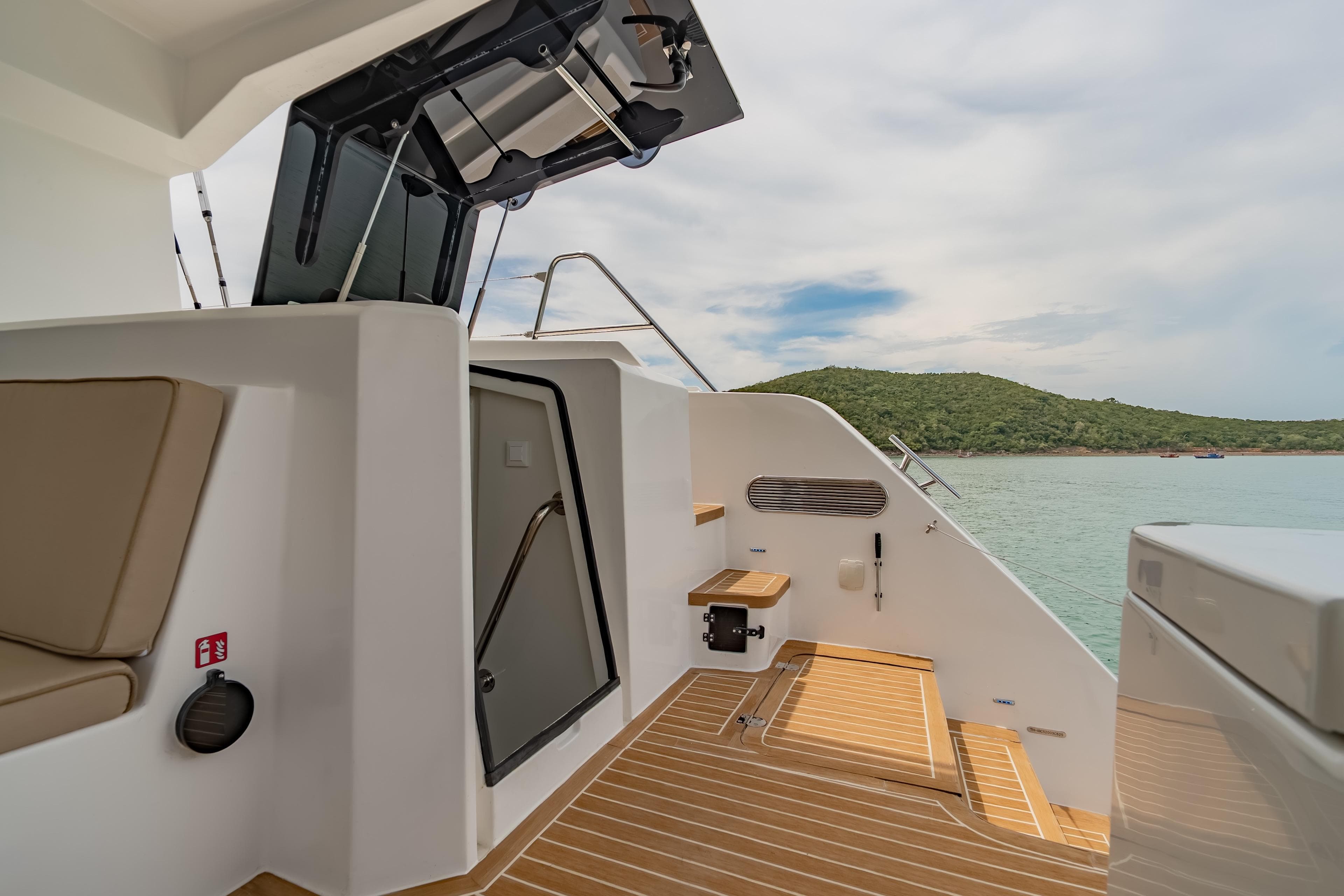 2026 Island Spirit 525E yacht deck with seating, steps, and scenic ocean view.