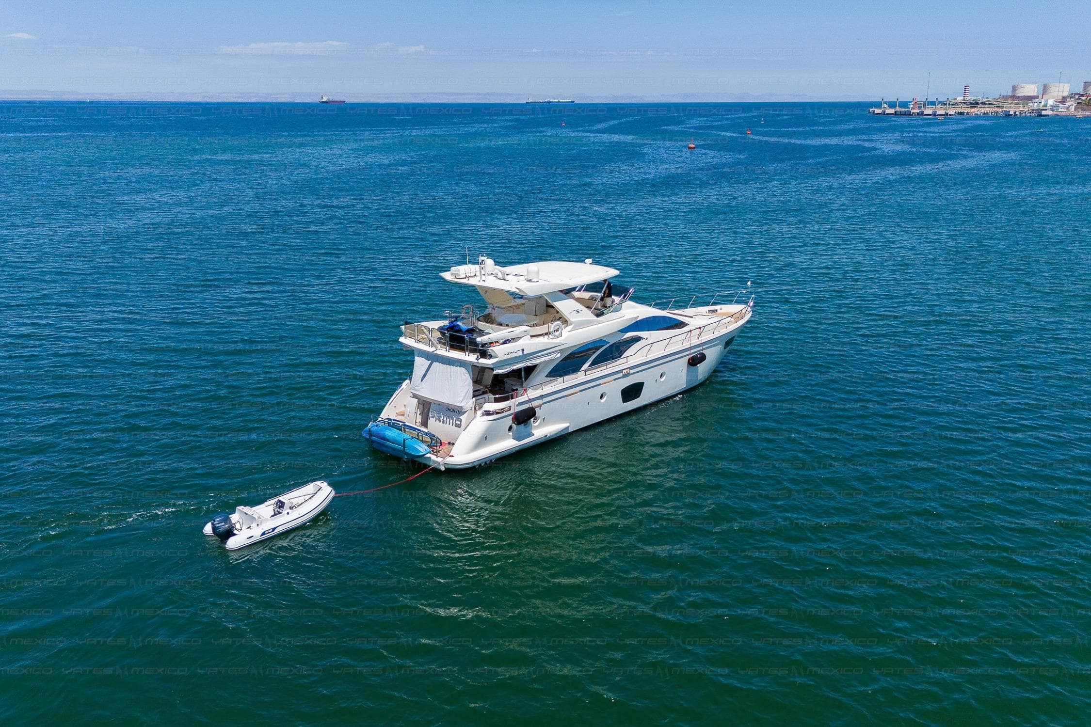 Luxurious 2009 Azimut 75 yacht anchored in serene blue waters with a small tender.