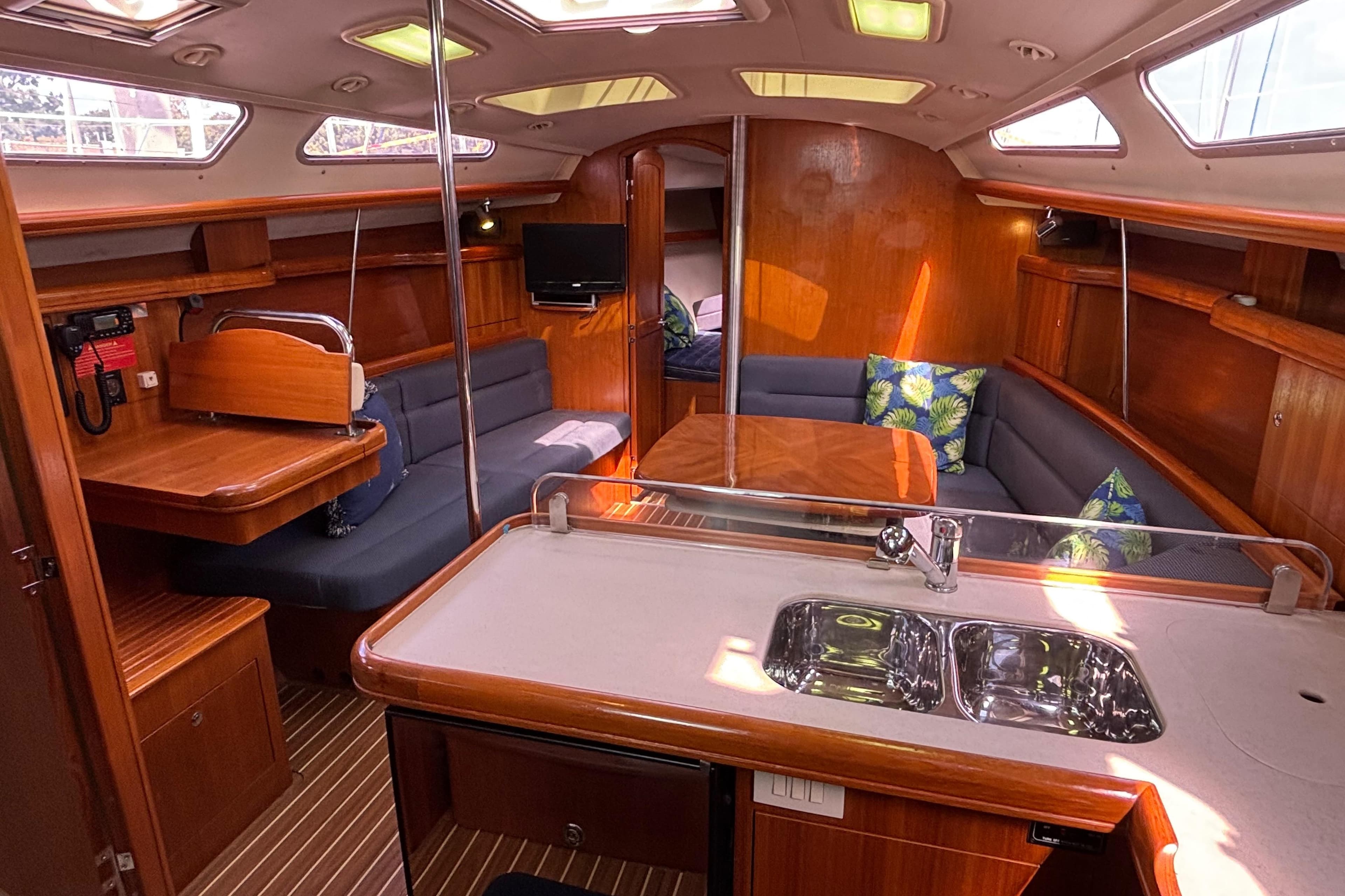 Interior of 2006 Hunter 38 sailboat with wood finish and cozy seating area.