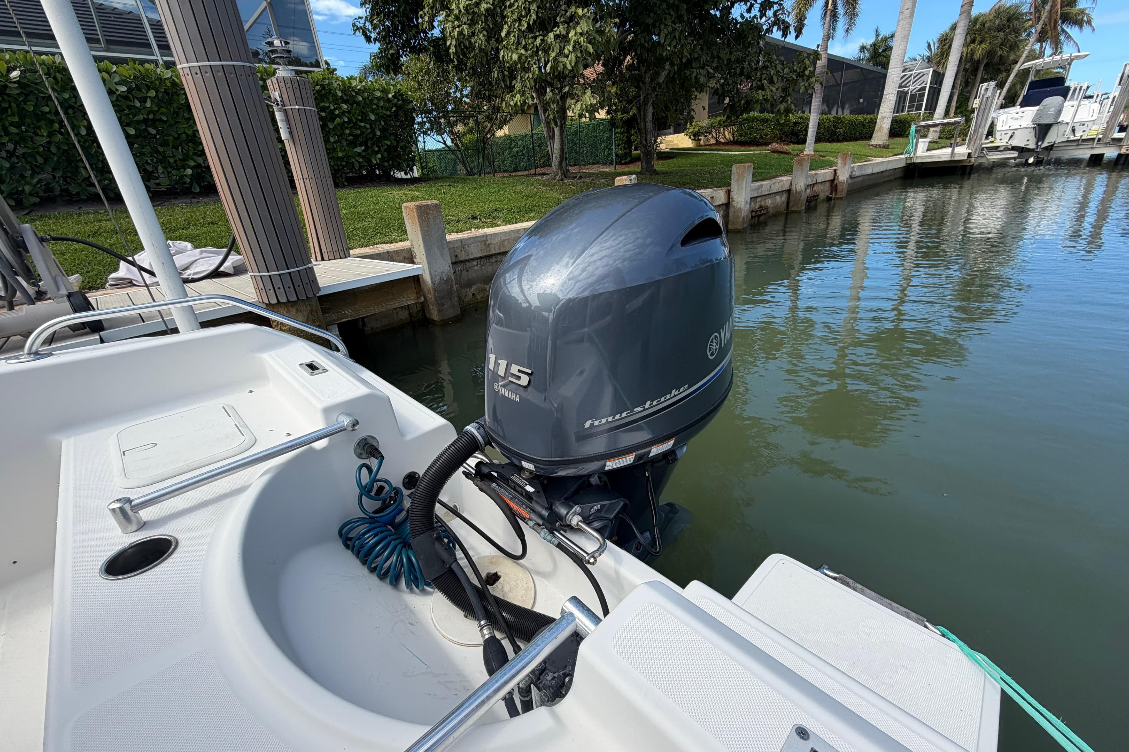 Boat with Yamaha 115 outboard motor docked in a serene marina setting.