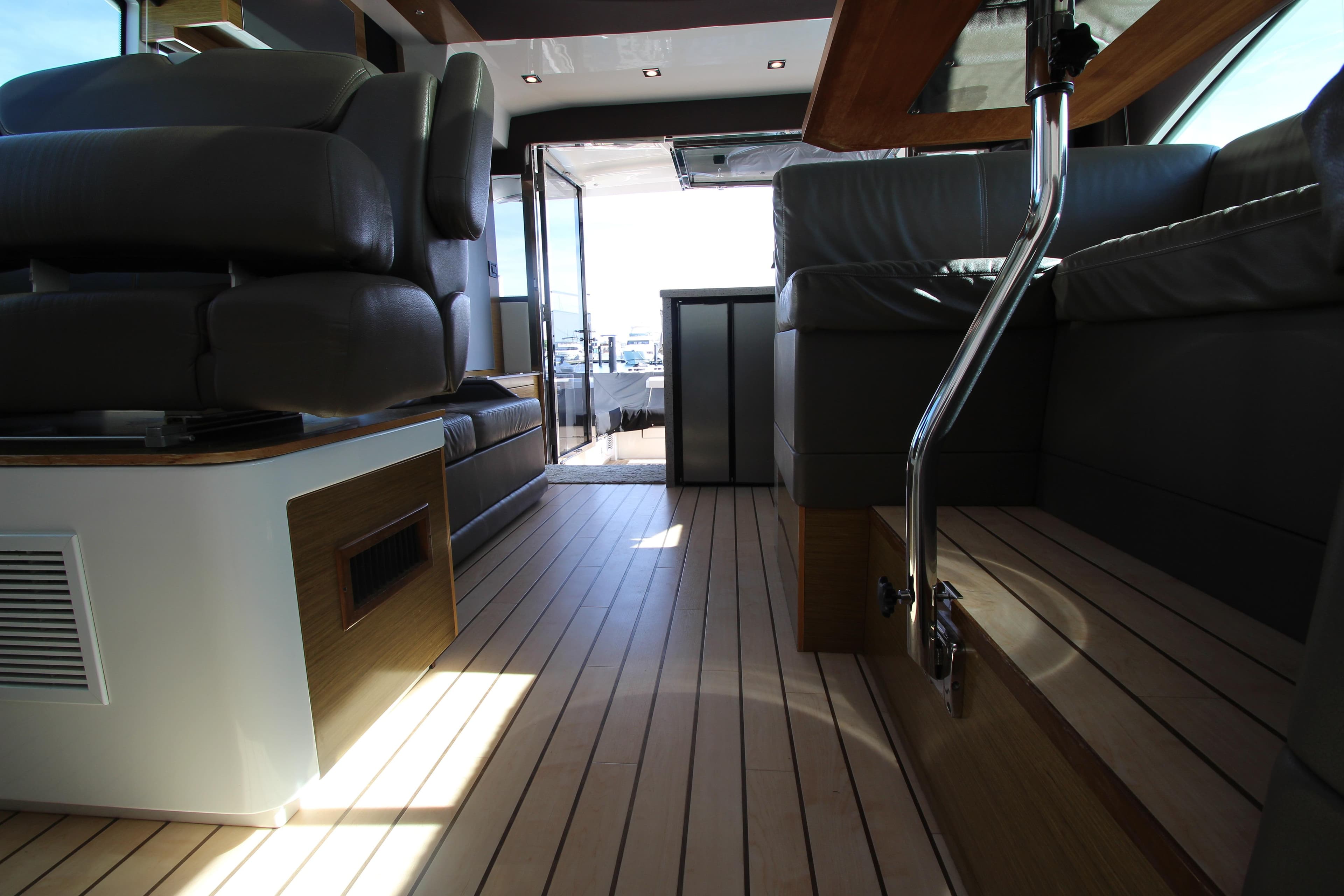 Interior of 2014 Cruisers Yachts 45 Cantius with sleek seating and wooden flooring.