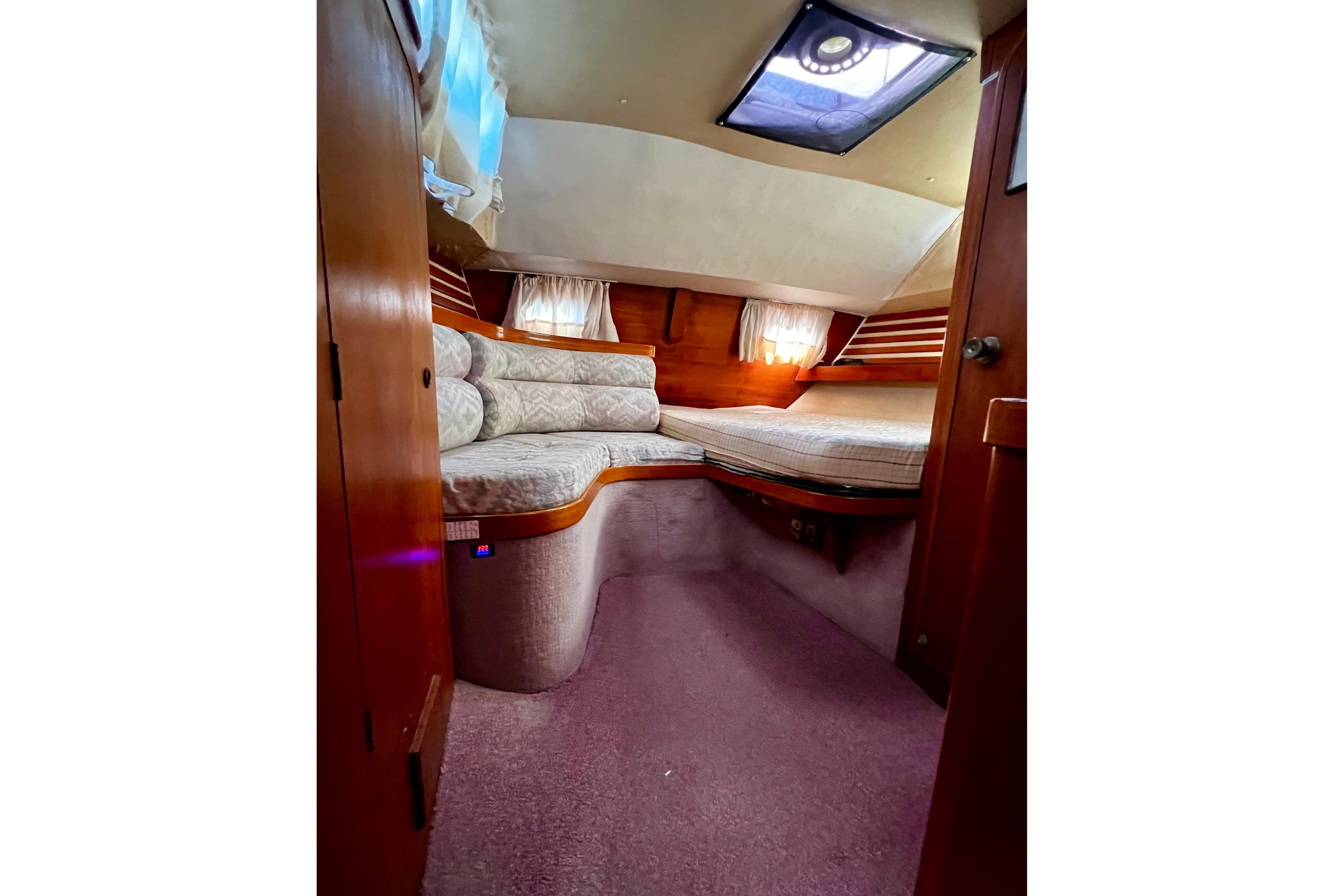 Cozy cabin interior of 1990 Moody 376 sailboat with plush seating and wooden accents.