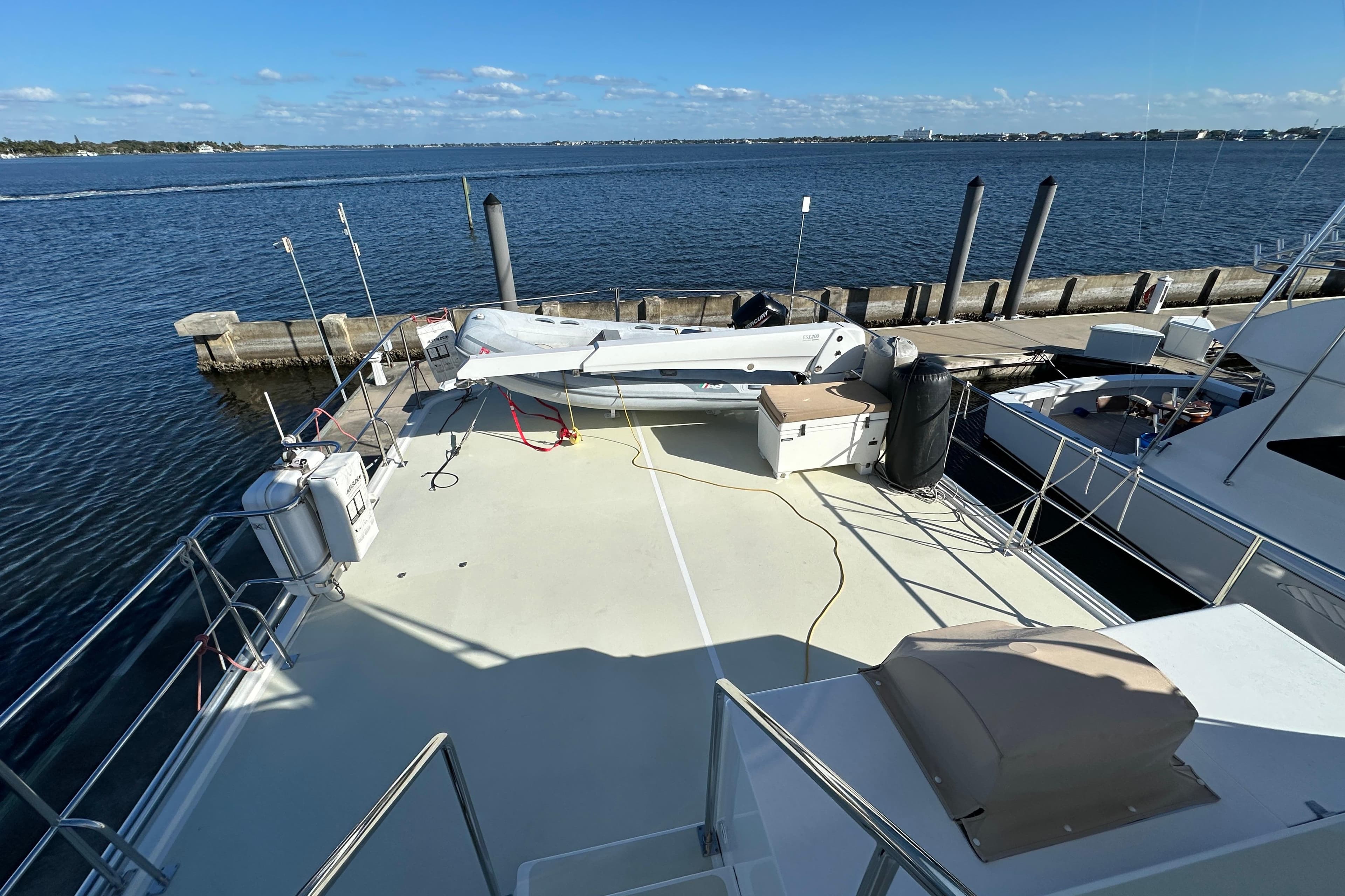 2017 Kadey-Krogen 58EB yacht deck with tender, docked by the waterfront.
