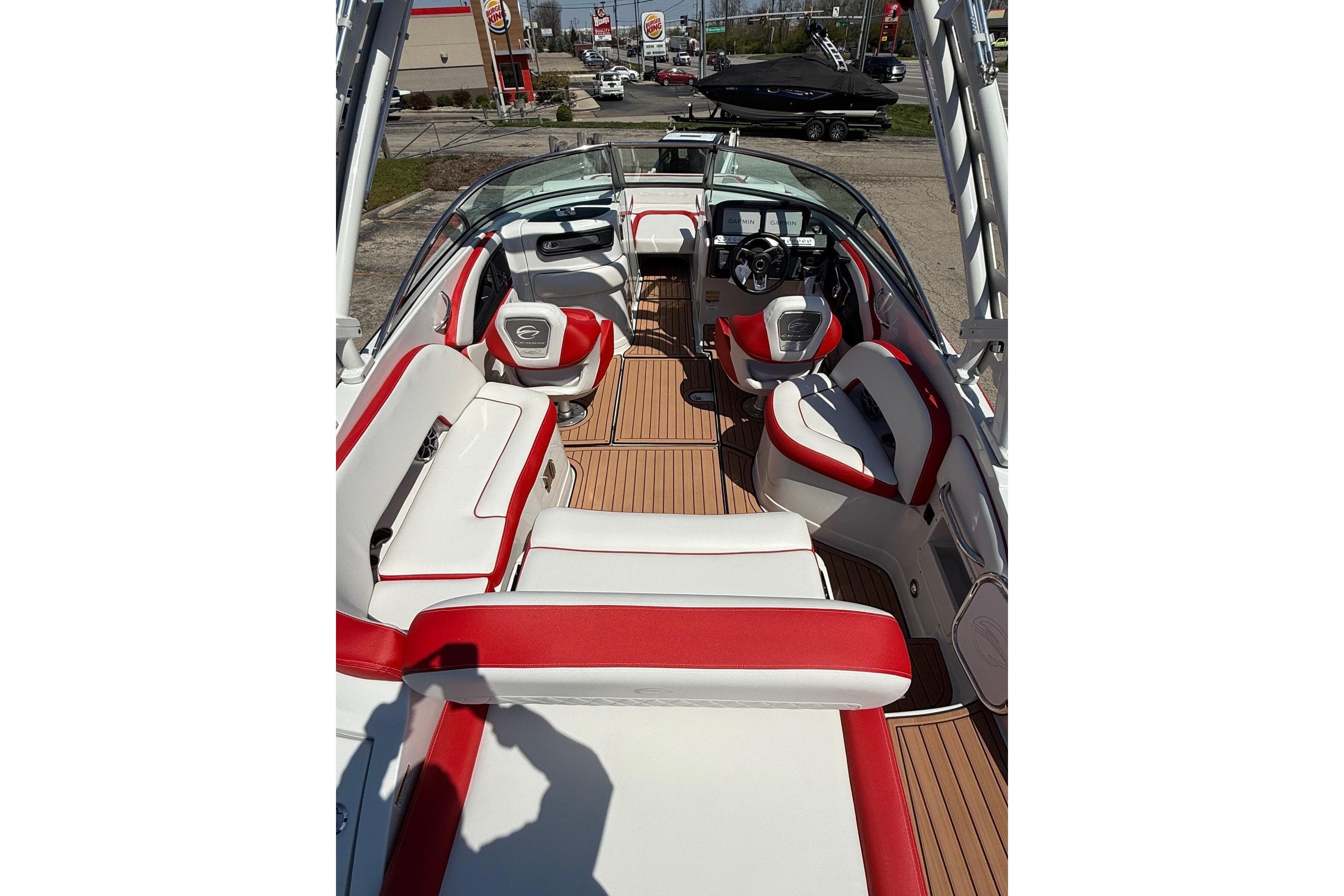 2025 Crownline Eclipse E235 boat interior with red and white seating, wood flooring, and steering console.