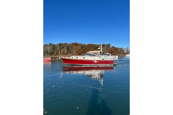 1998 Grand Banks 38 Eastbay EX boat on calm water, clear blue sky background.