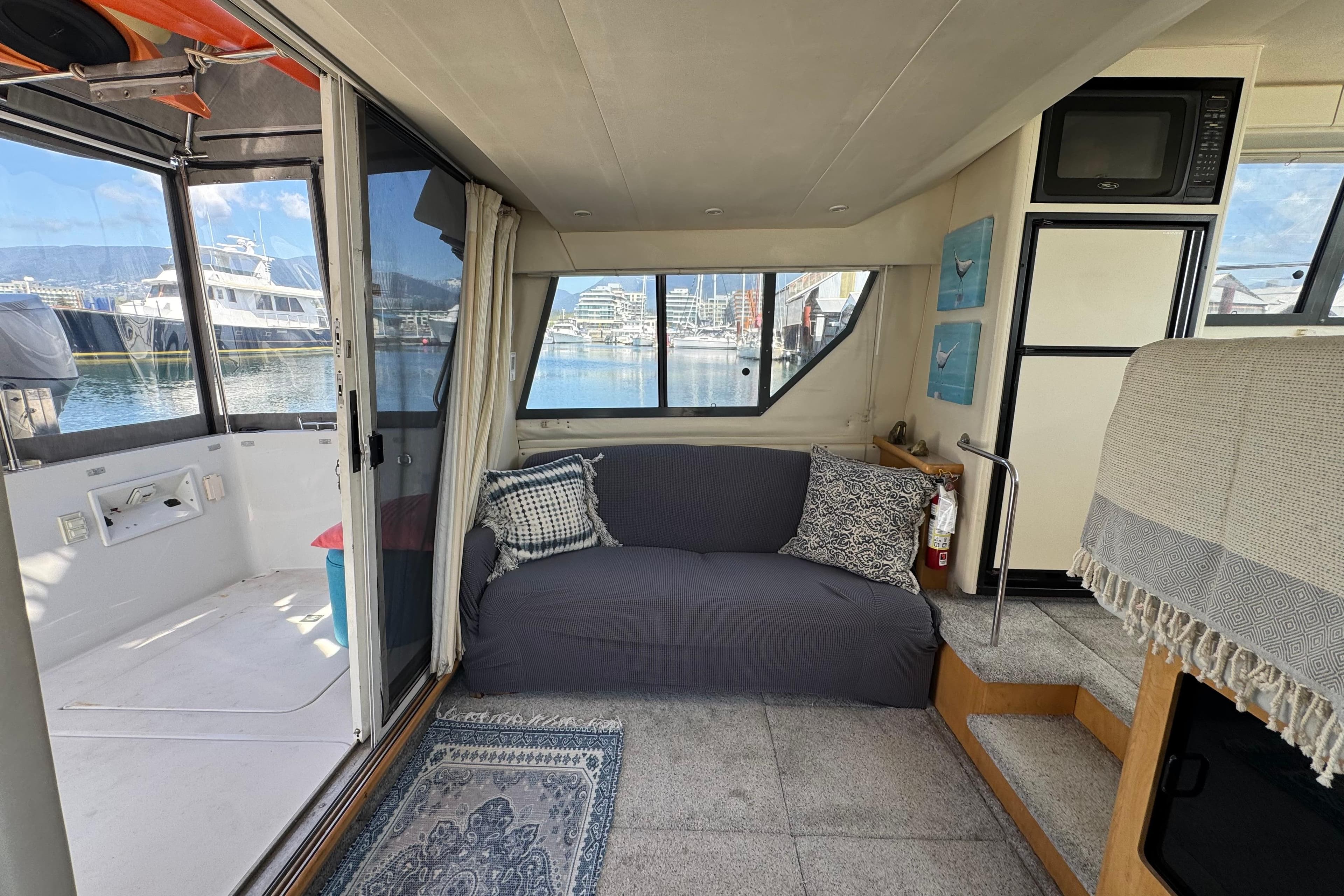 Interior of a 1996 Carver 370 Voyager yacht with cozy seating and marina view.