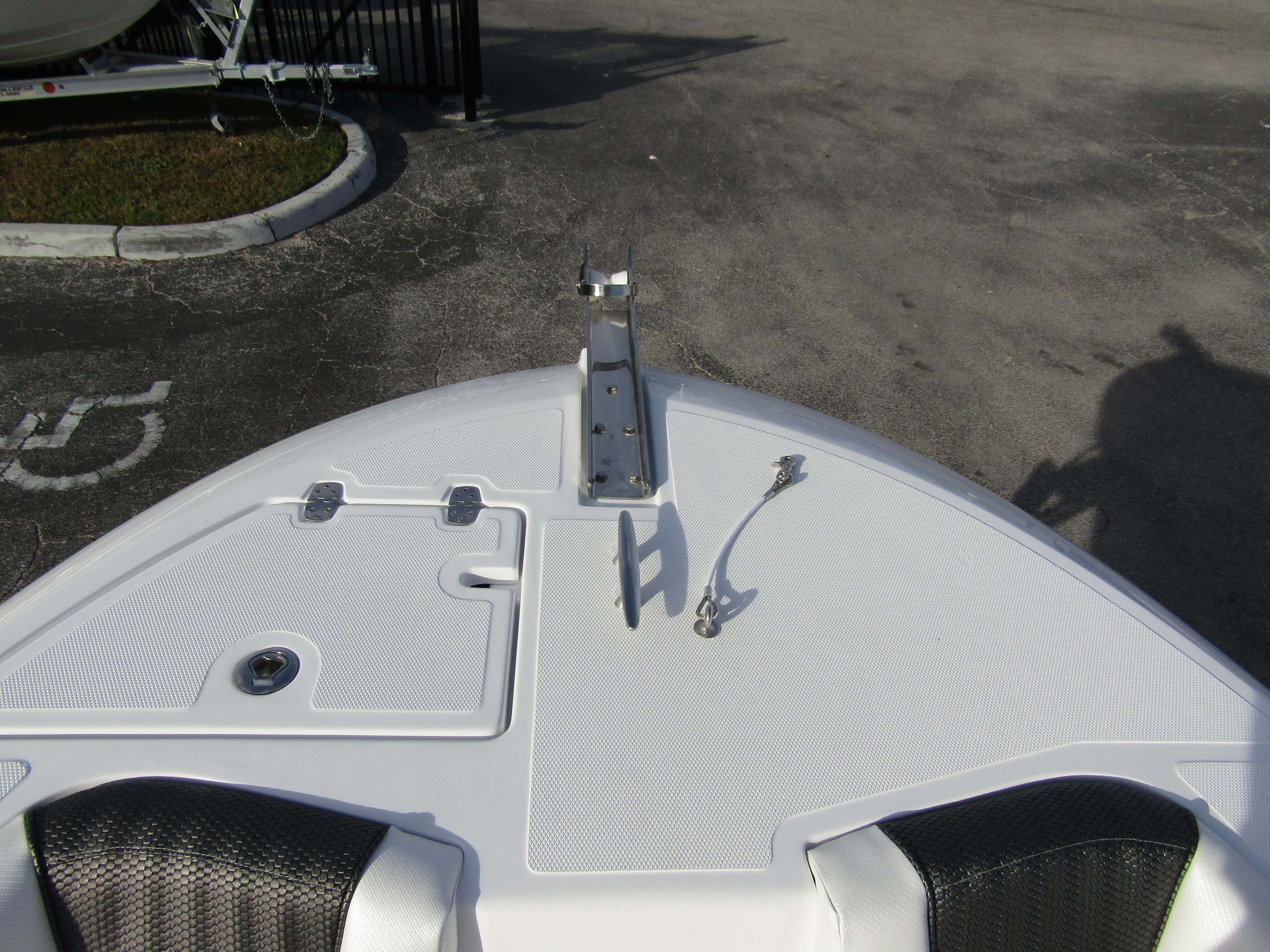 Bow of 2025 Wellcraft 243 Fisherman boat with anchor mount and storage hatches.