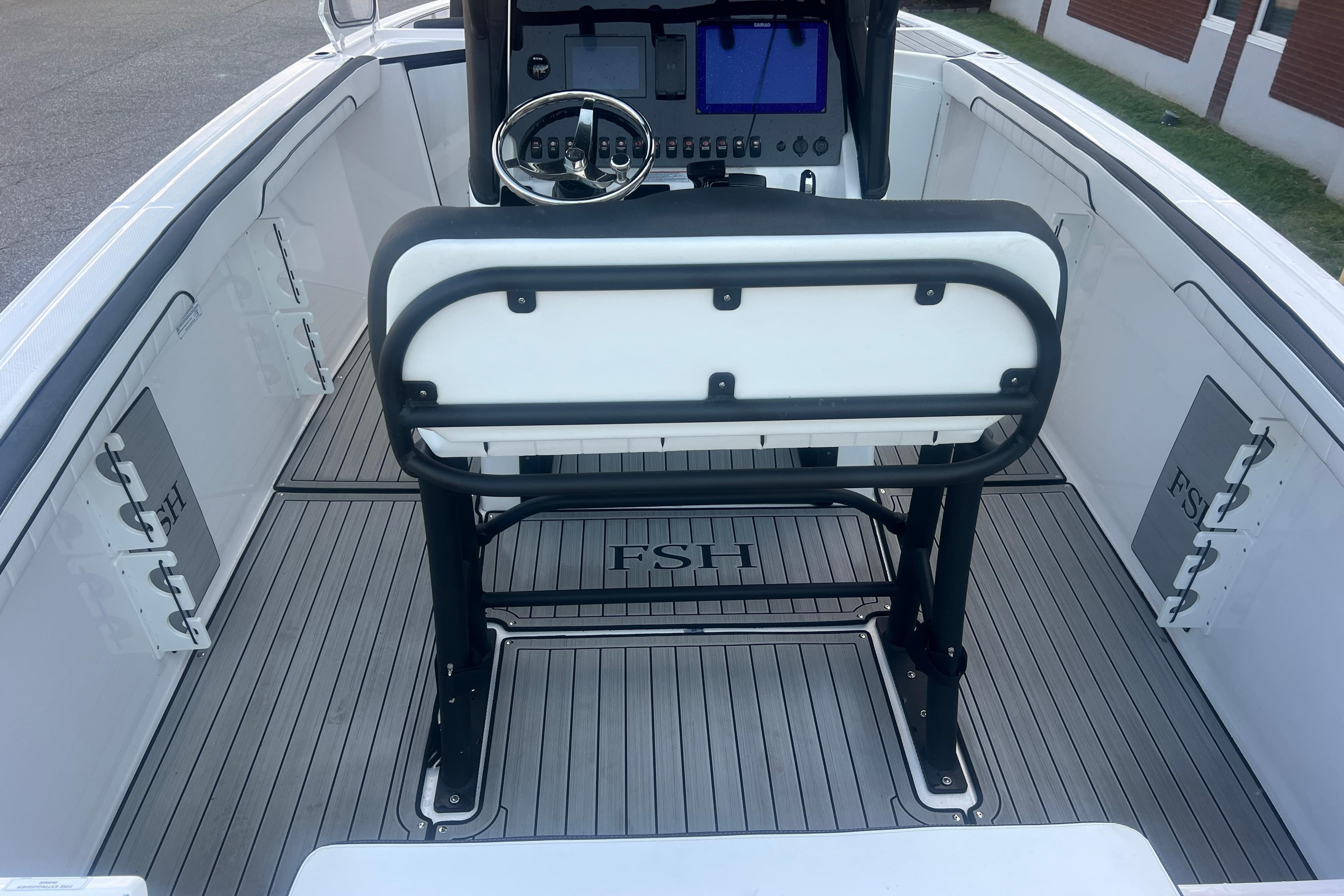 2024 Yamaha Boats 255 FSH Sport H interior with steering console and seating.