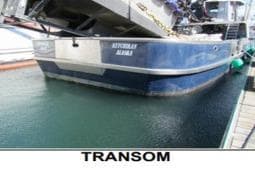 Transom view of 1979 Custom Longliner 58 boat docked in water.