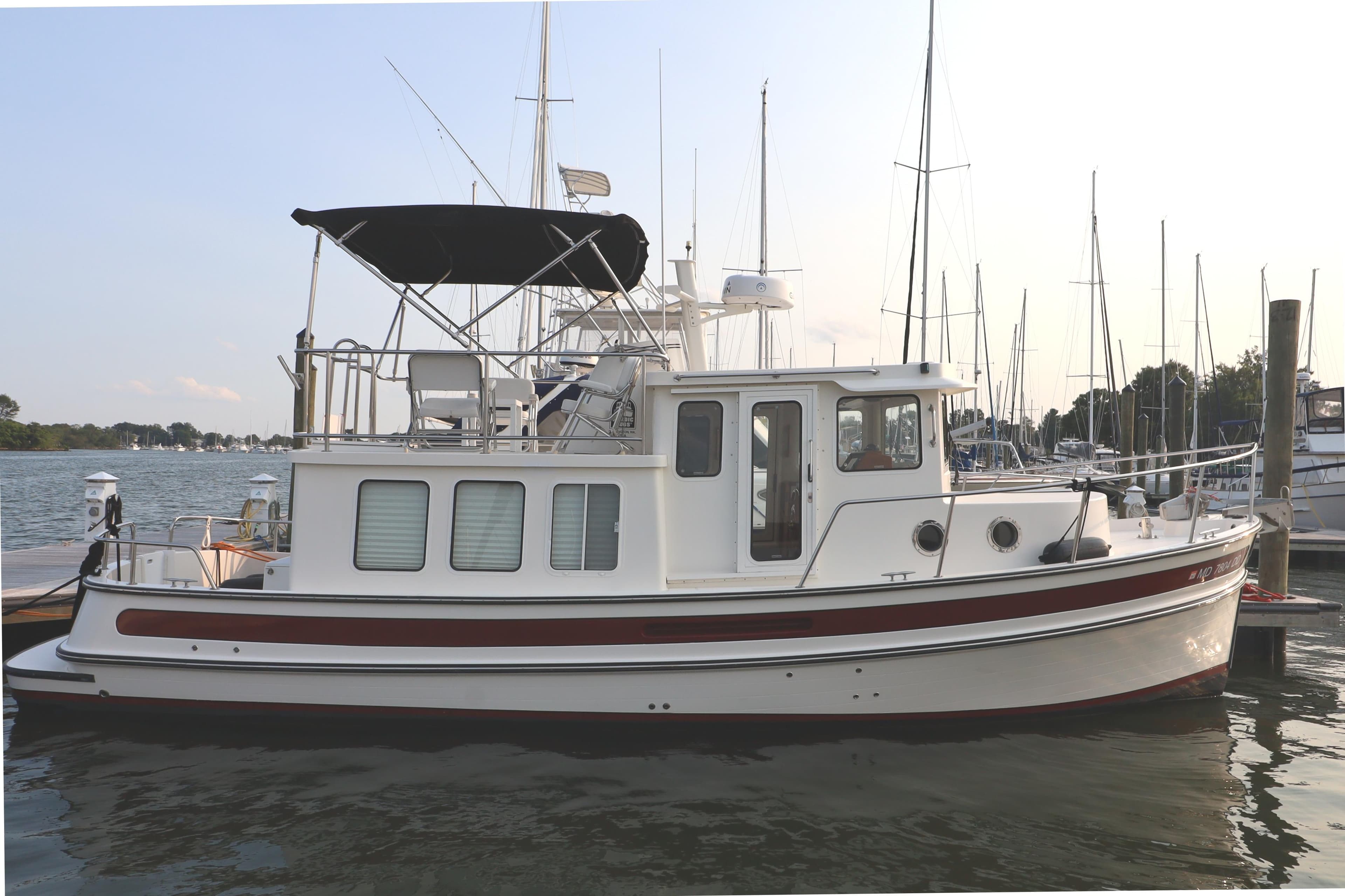 2007 Nordic Tug 32 docked at marina, featuring classic design and spacious deck.