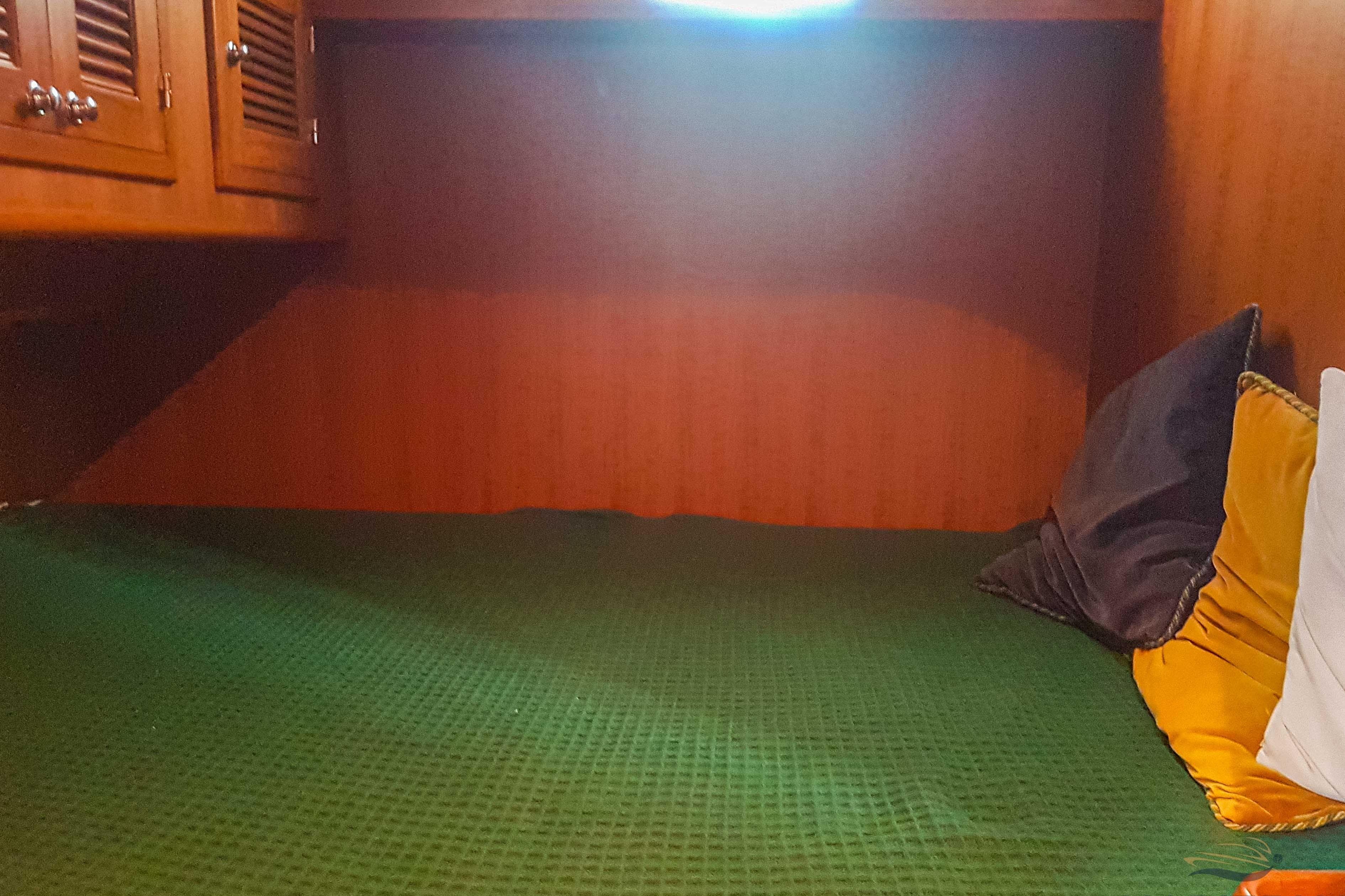 Cozy cabin interior of 2009 Adagio 51.5 Europa with green bedding and colorful pillows.