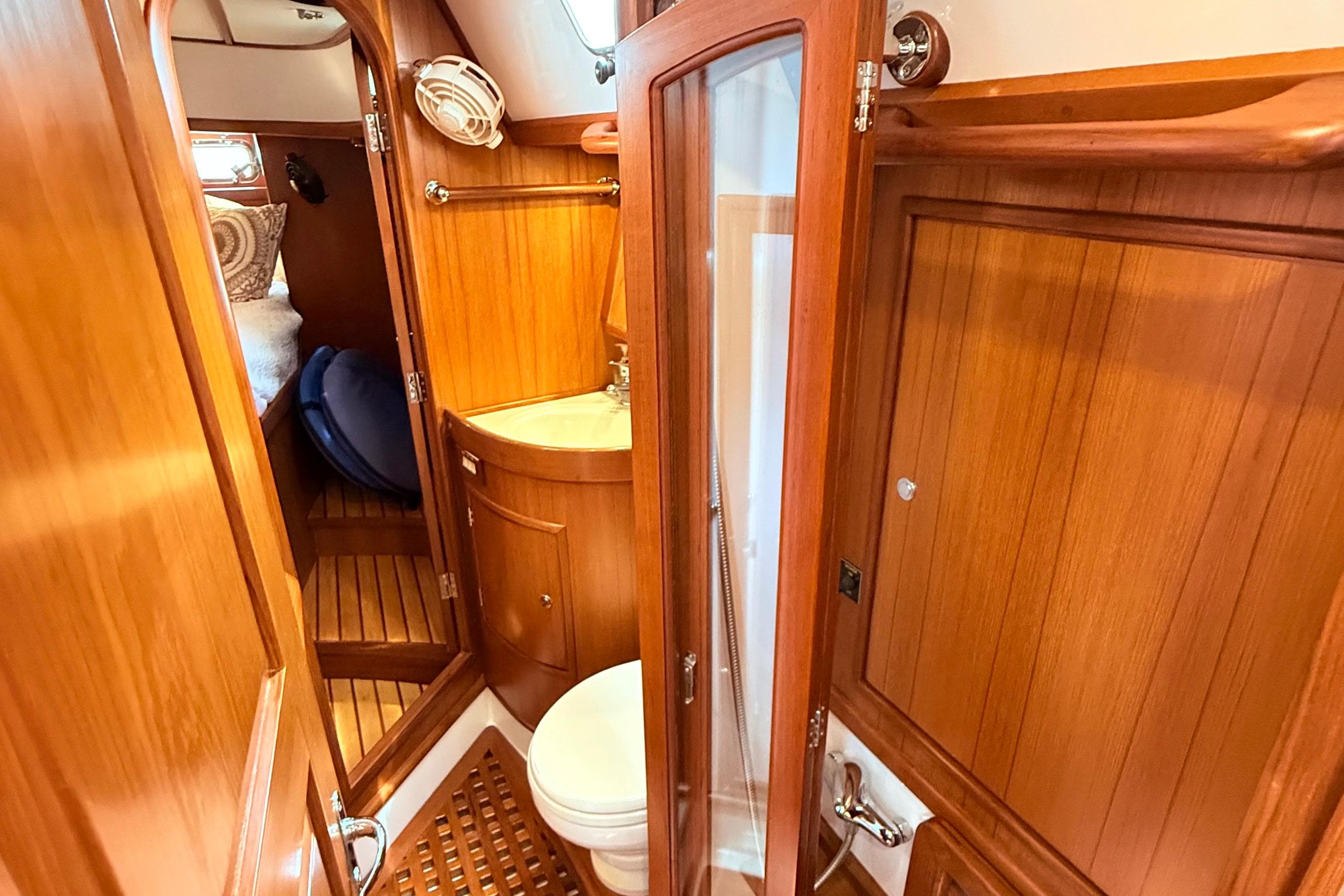 Interior of 2008 Hylas 46 yacht featuring wooden cabinetry and compact bathroom.