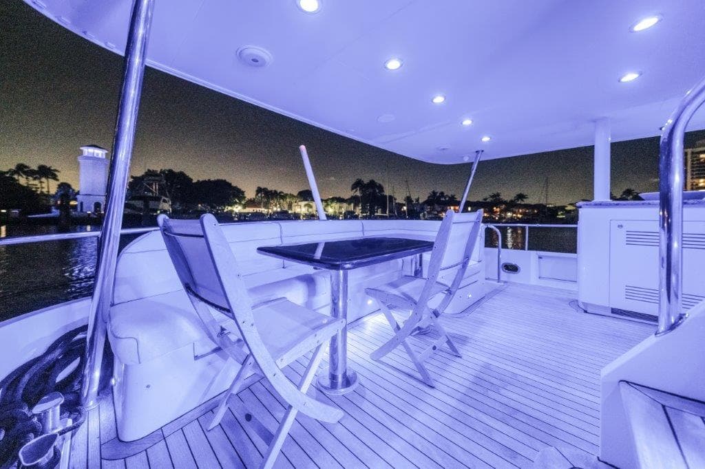 Luxurious 2006 Cheoy Lee motor yacht deck with night lighting and waterfront view.