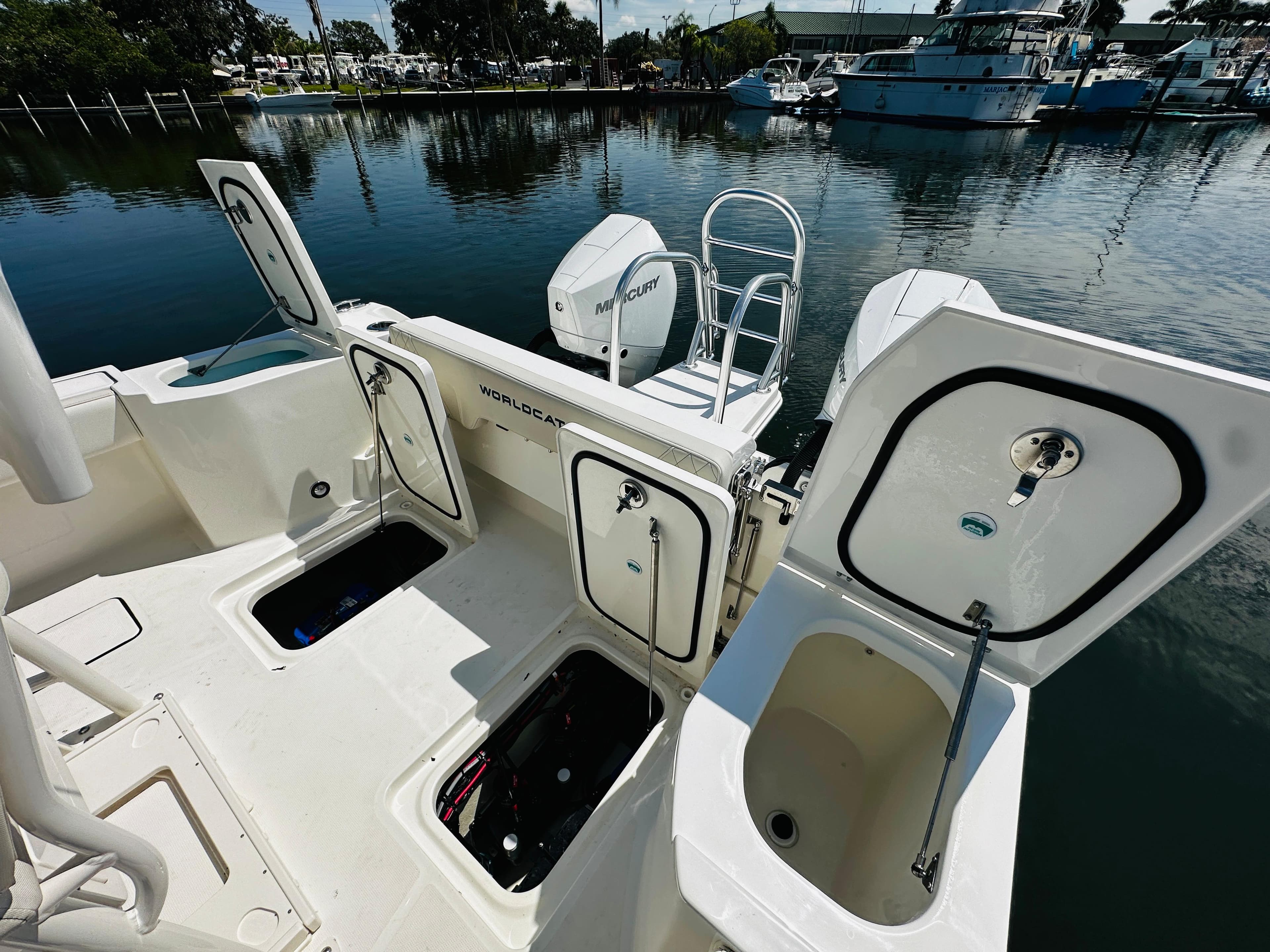 2024 World Cat 260 CC-X boat with open storage compartments at the dock.