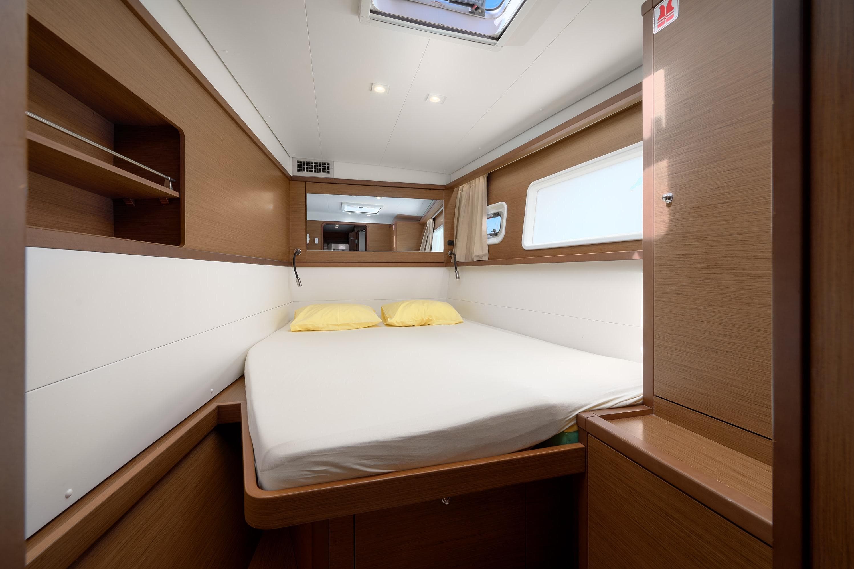 Interior cabin of 2018 Lagoon 450 yacht with cozy bed and wooden furnishings.