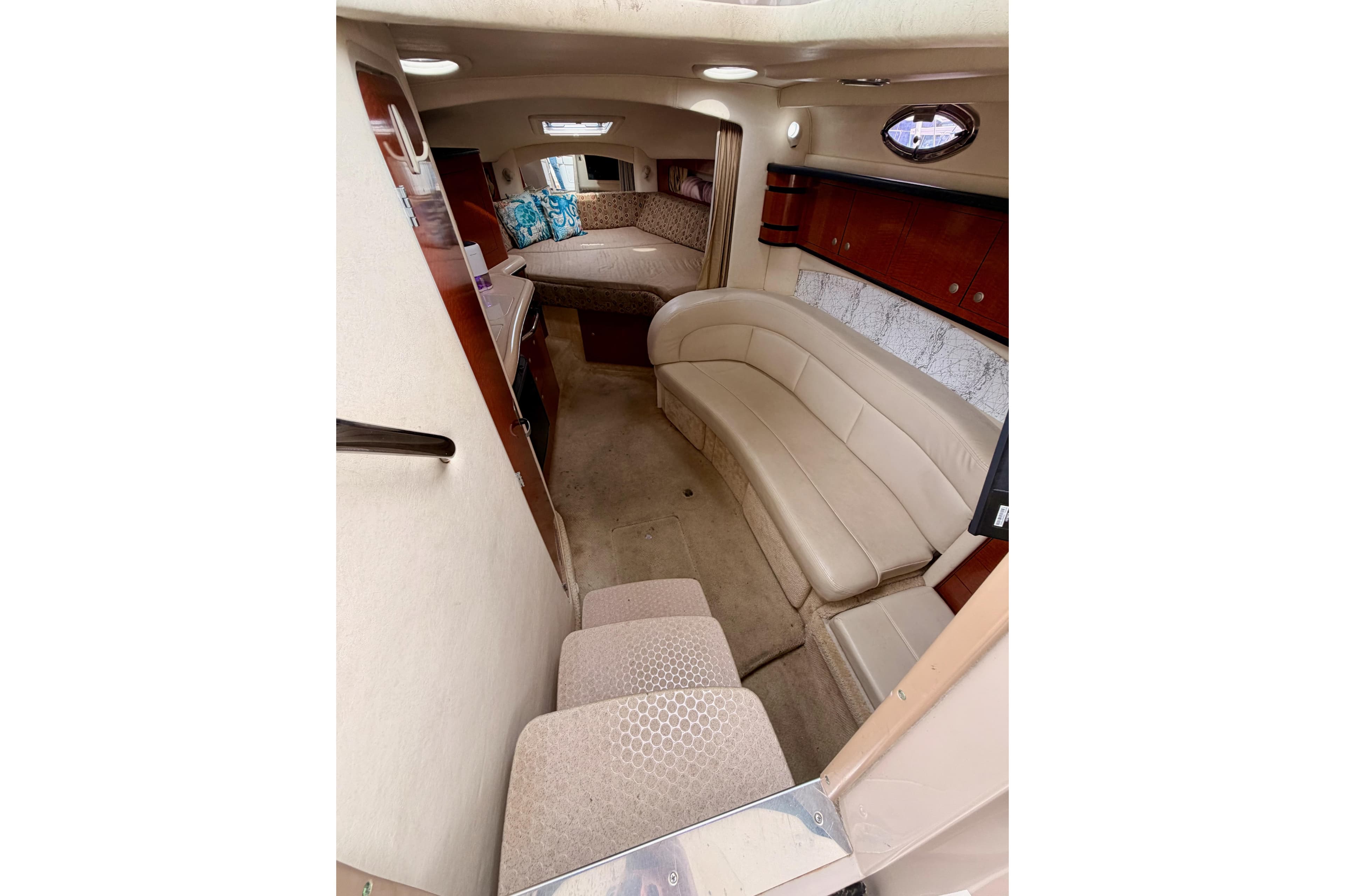 Interior of 2005 Sea Ray 300 Sundancer boat with beige seating and cozy cabin.