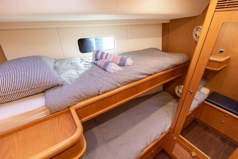 Cozy cabin interior of 2015 Discovery 58 yacht with bunk beds and wooden finish.