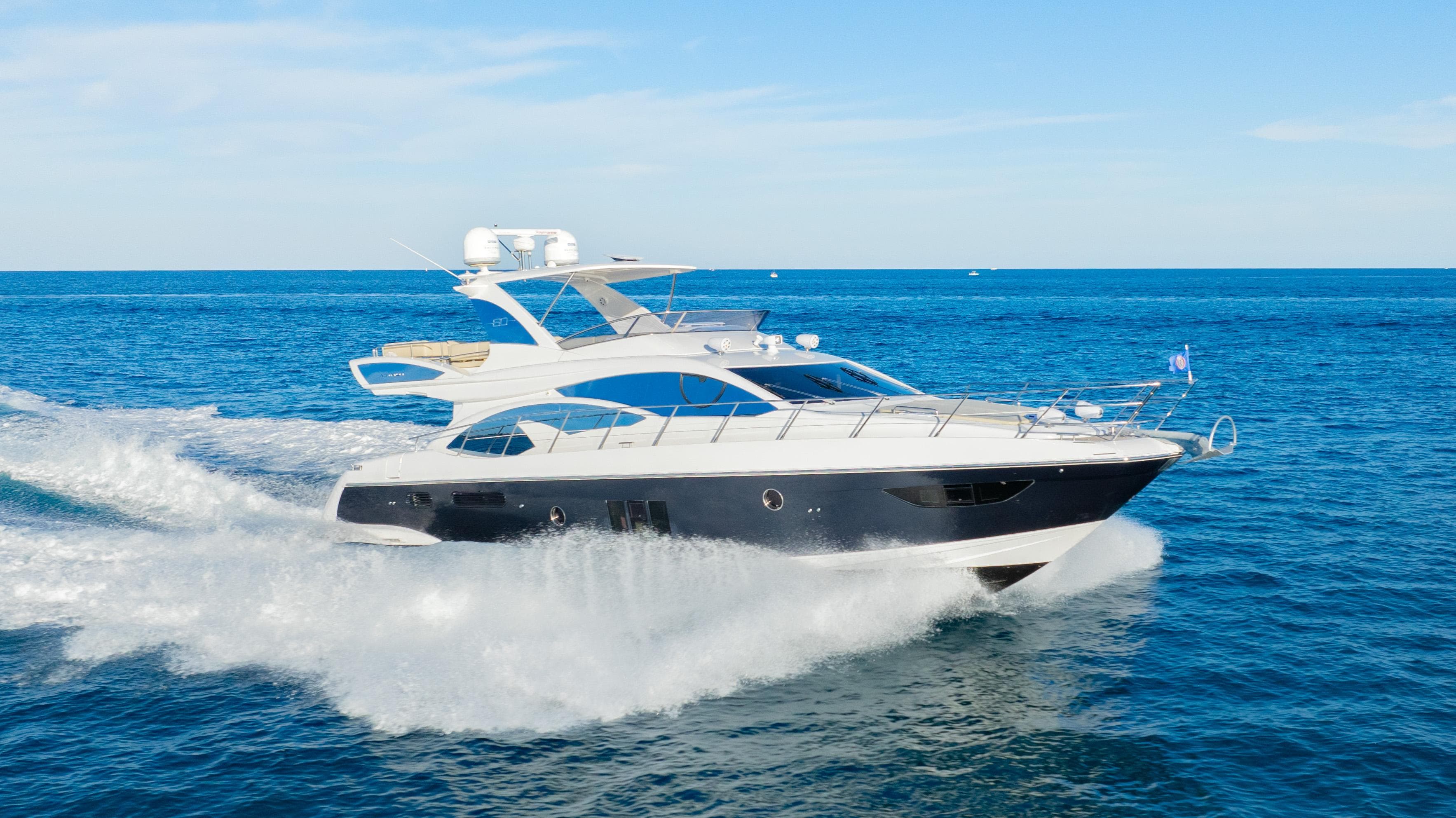 Azimut 60 Flybridge 2017 yacht cruising on open sea under clear blue sky.