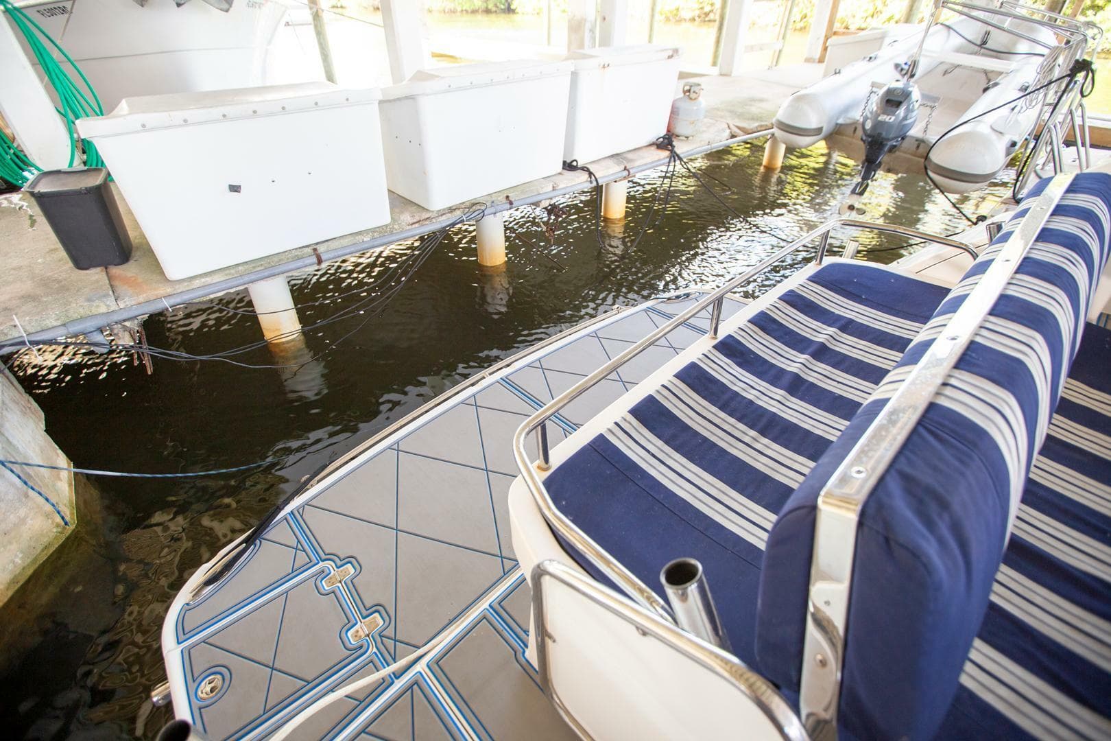 2008 Regal 38 boat interior with striped seating, docked in a covered marina.