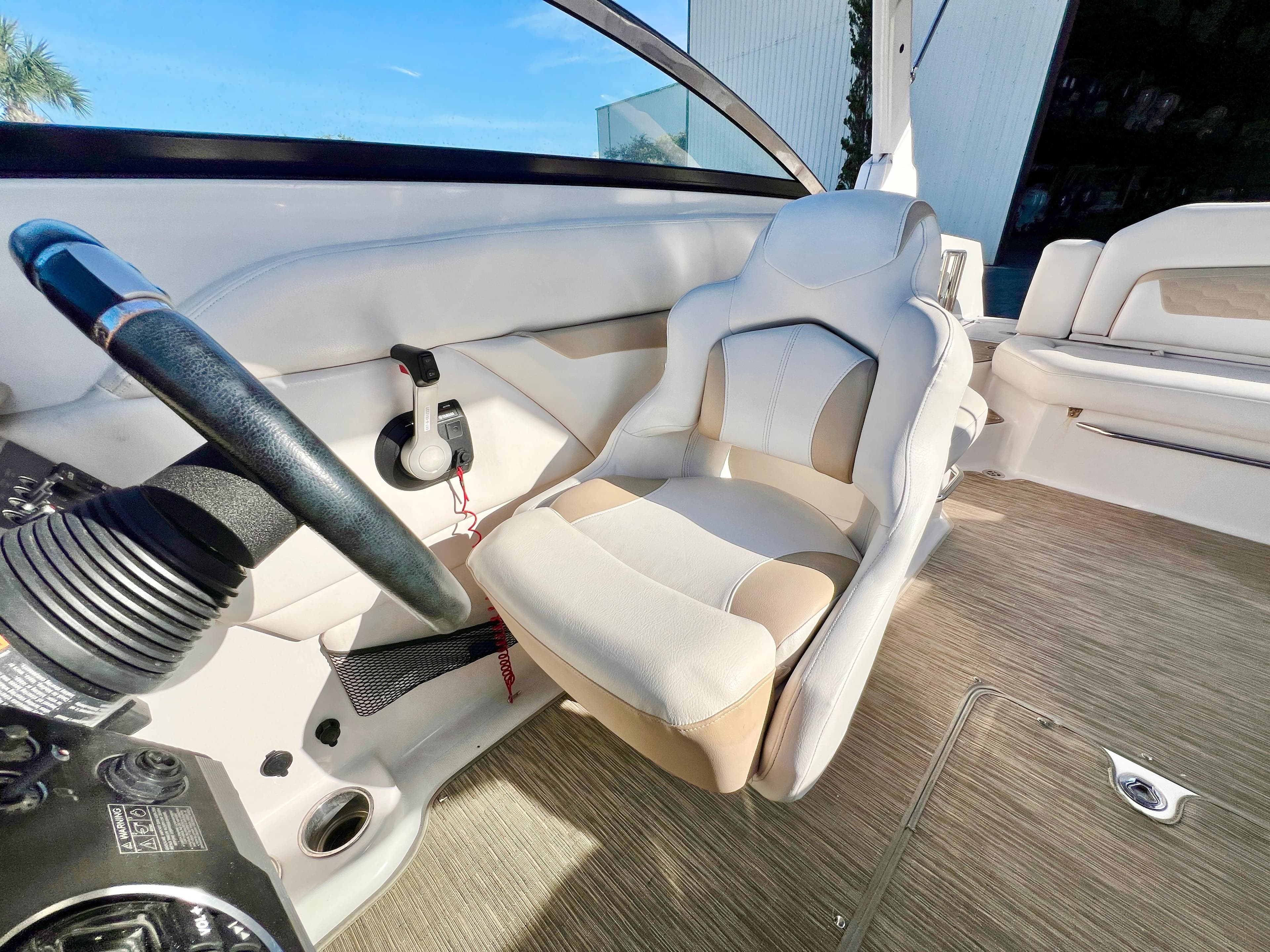 2018 Four Winns HD270 OB boat interior with steering wheel and plush seating.