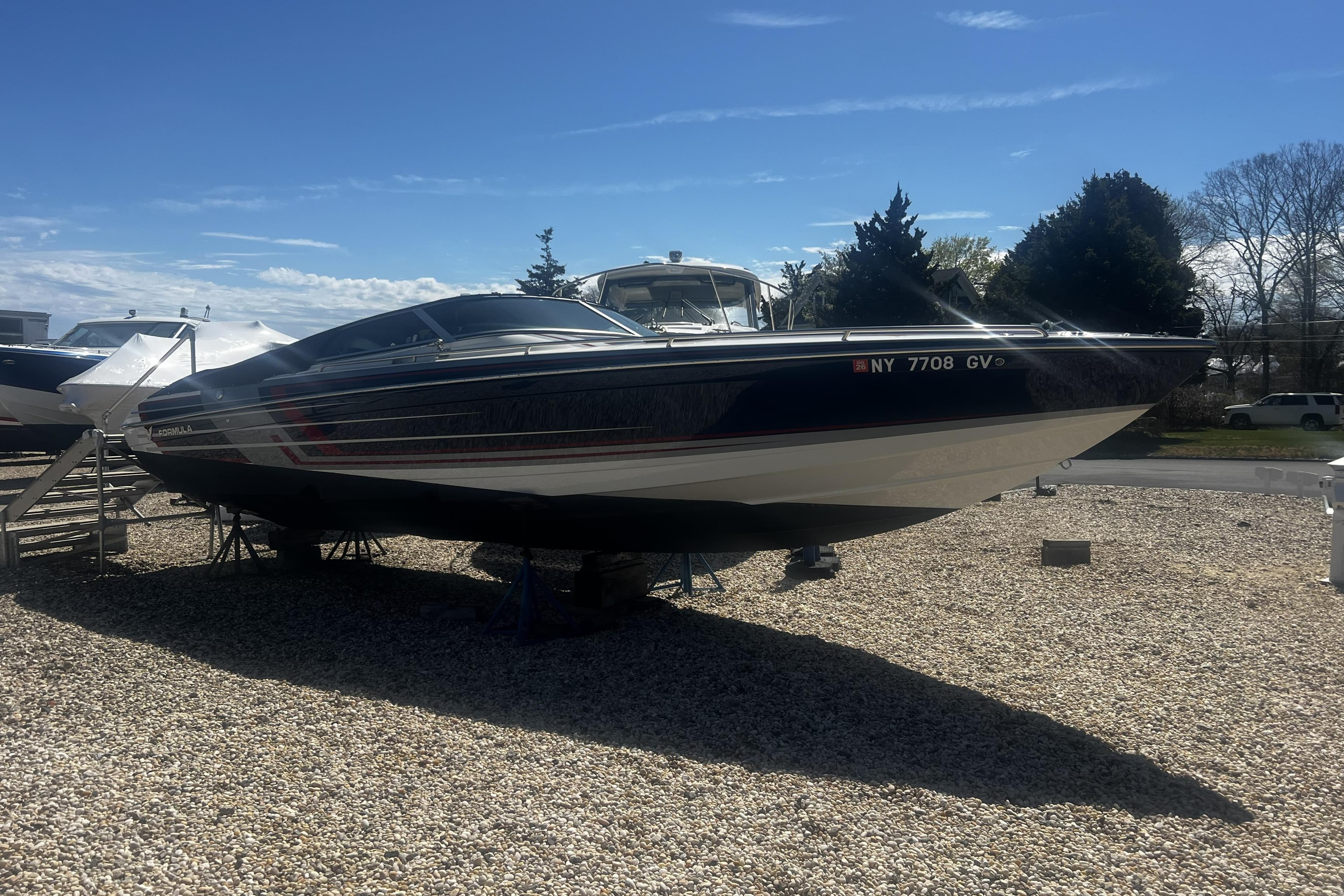 2017 Formula 292 FASTech boat on gravel lot under clear blue sky.